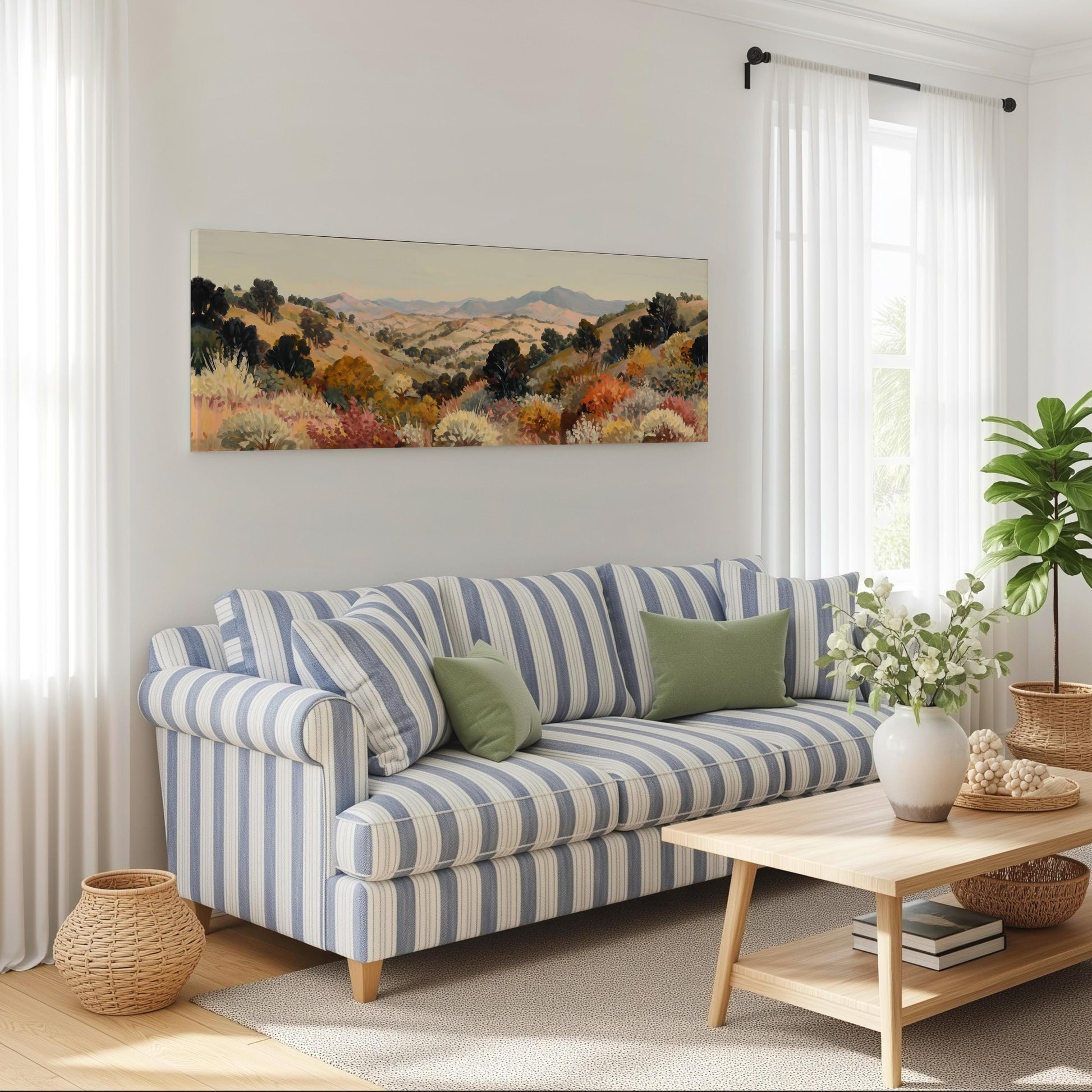 a cozy living room with a striped blue and white sofa, a wooden coffee table, and a large landscape painting hanging on the wall above the sofa.