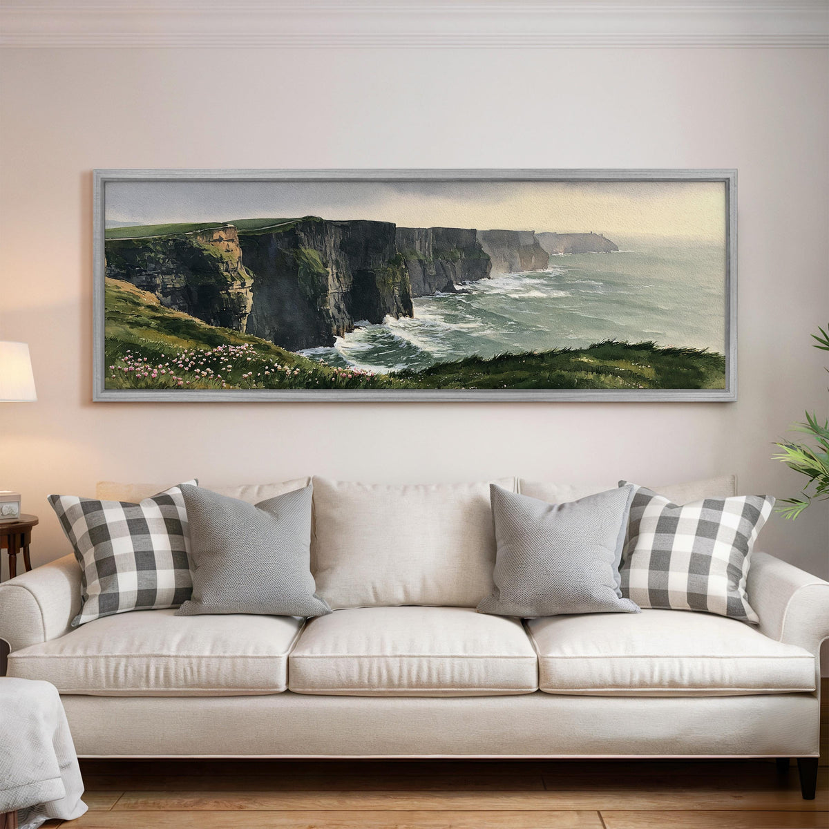 Green sea cliffs with wildflowers panoramic canvas print above a white sofa in a bright living room