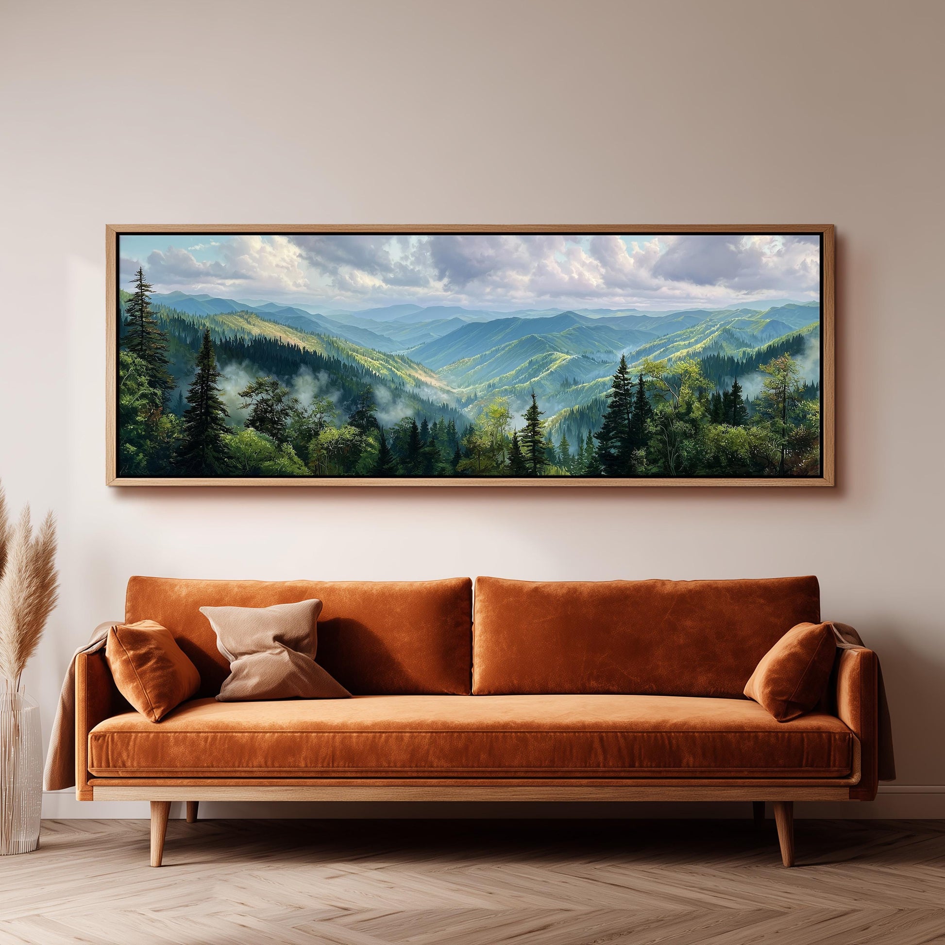 a large landscape painting hanging on a wall above a brown sofa with orange cushions.