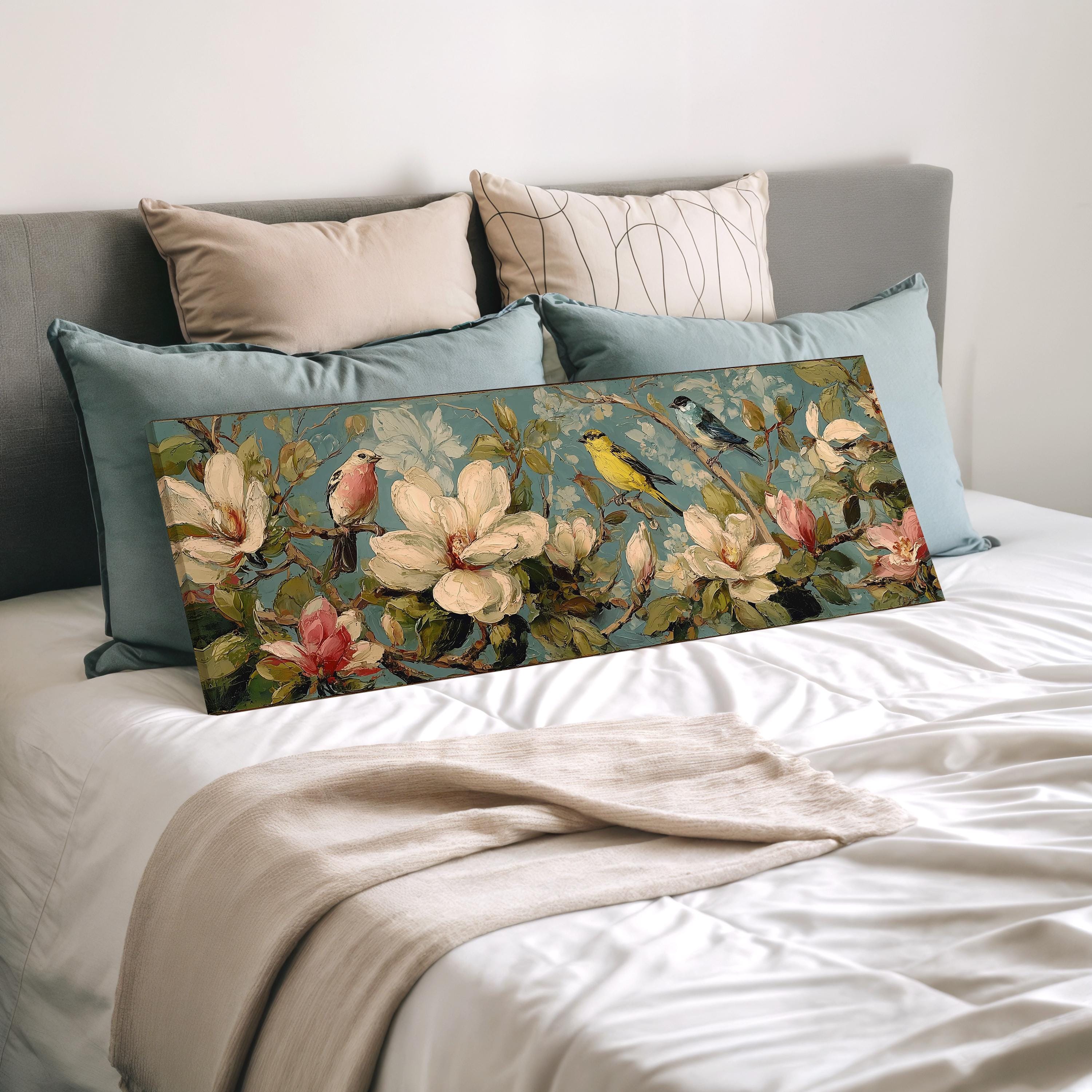 a bedroom with a bed and a large floral print on the bed. The print features a variety of flowers and birds, creating a vibrant and nature-inspired design.
