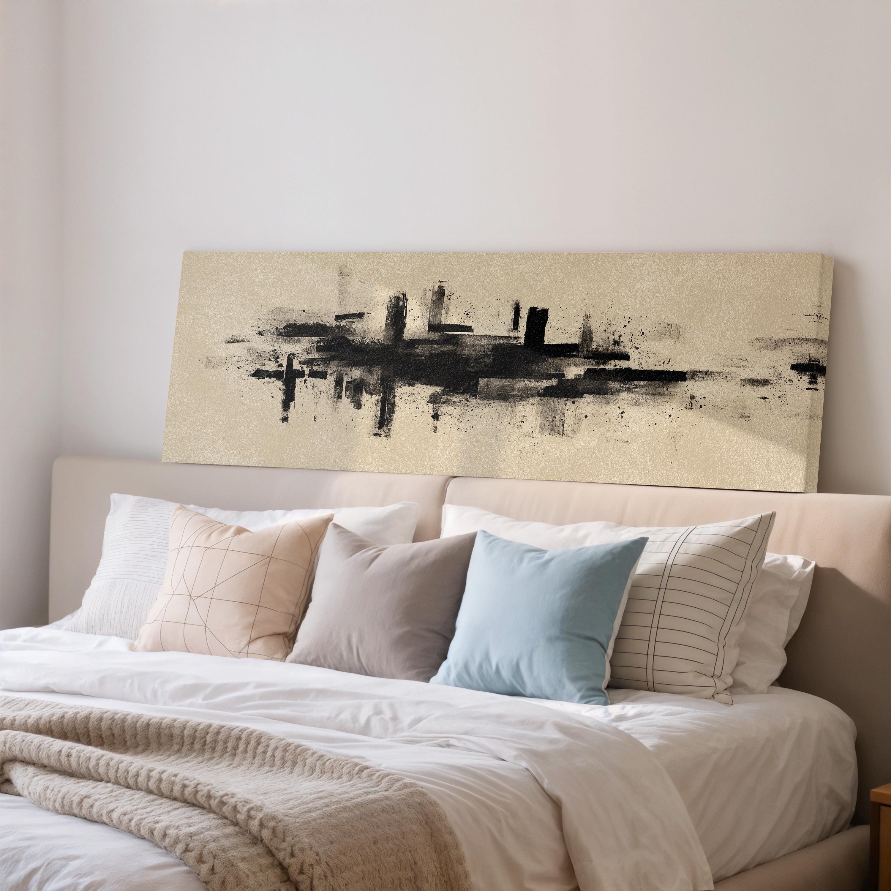 a well-made bed with a large abstract painting hanging above it. The bed has white sheets and pillows, and the painting features a black and white abstract design.