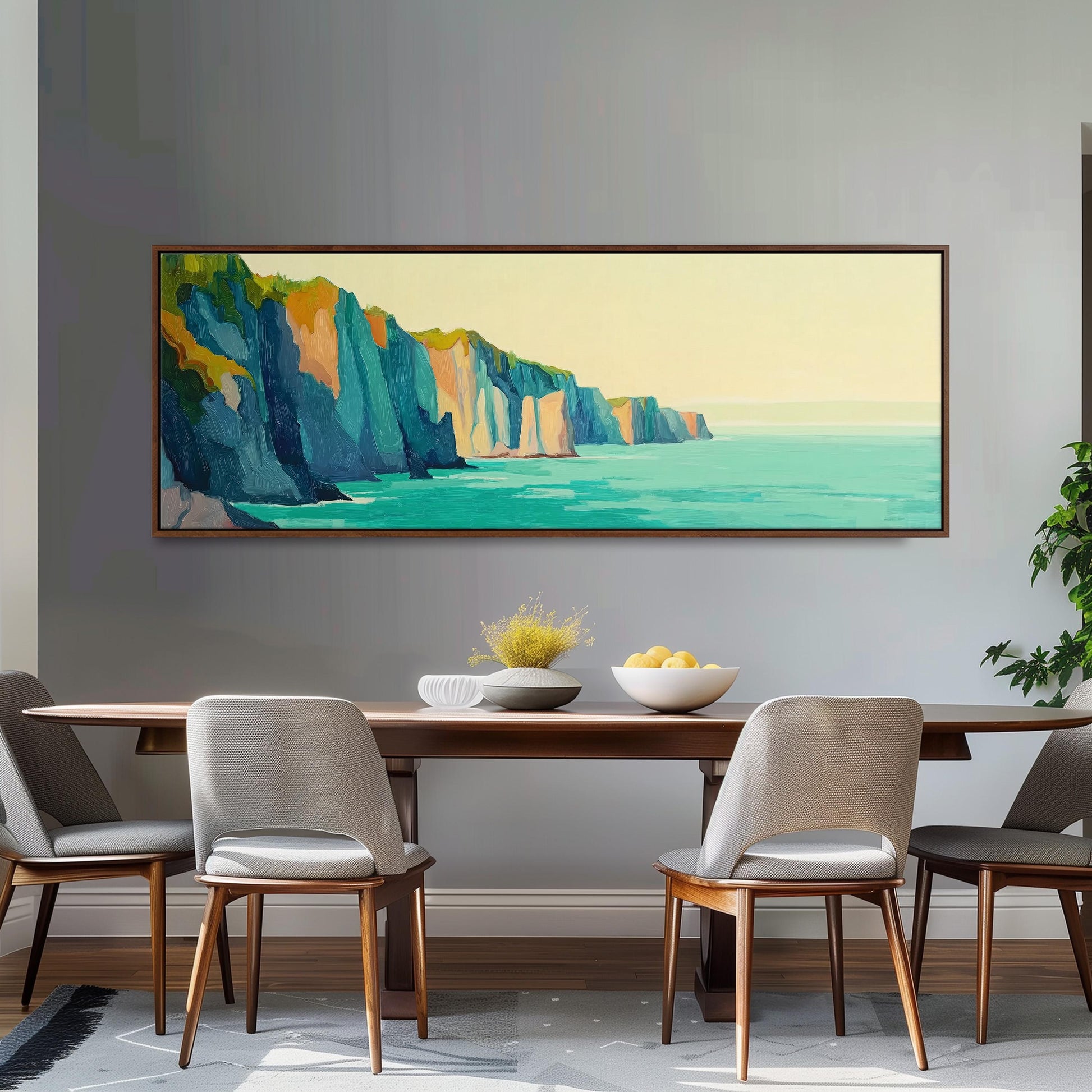 a dining room with a large painting of a cliff overlooking the ocean hanging on the wall above a wooden dining table with four chairs.