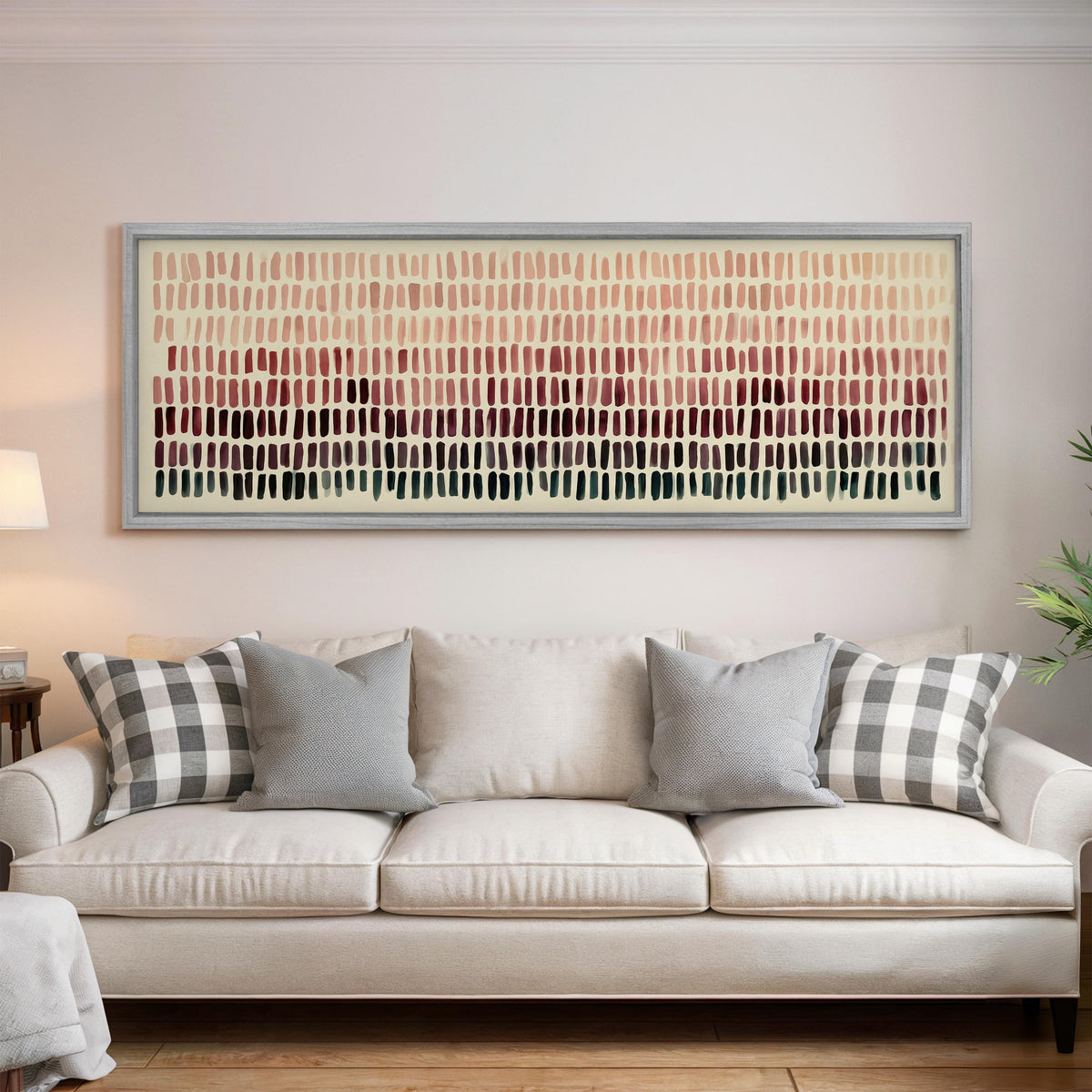 Brushmarks fading from blush to deep maroon panoramic canvas print above a white sofa in a bright living room