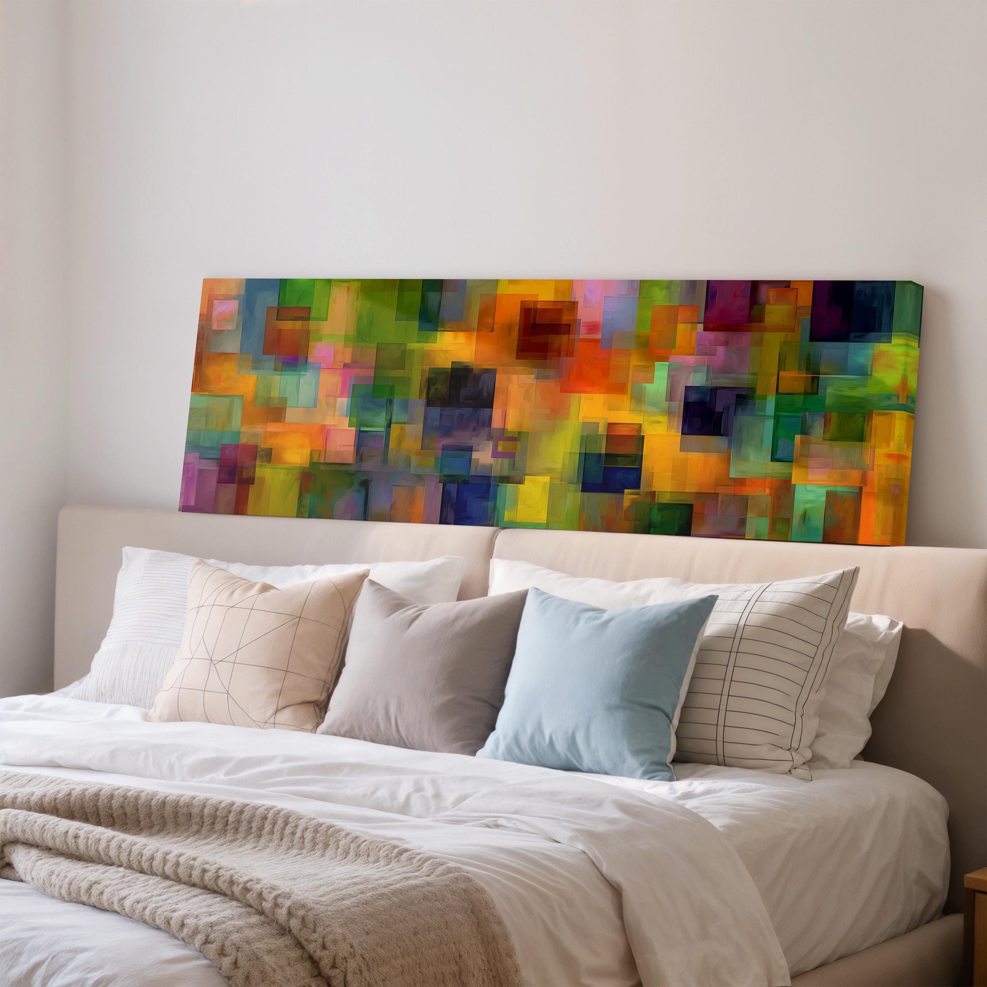 a large, colorful abstract painting hanging on a wall above a bed with white pillows and a gray blanket.