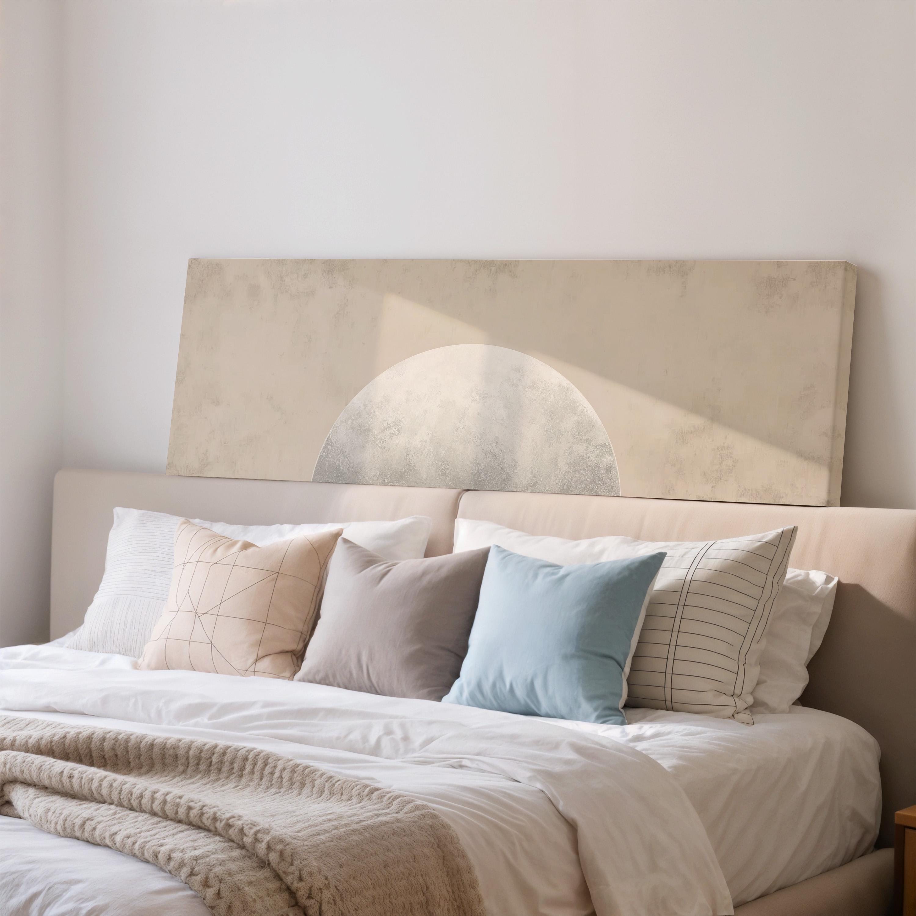 a neatly made bed with a variety of pillows and a blanket, creating a cozy and inviting atmosphere.