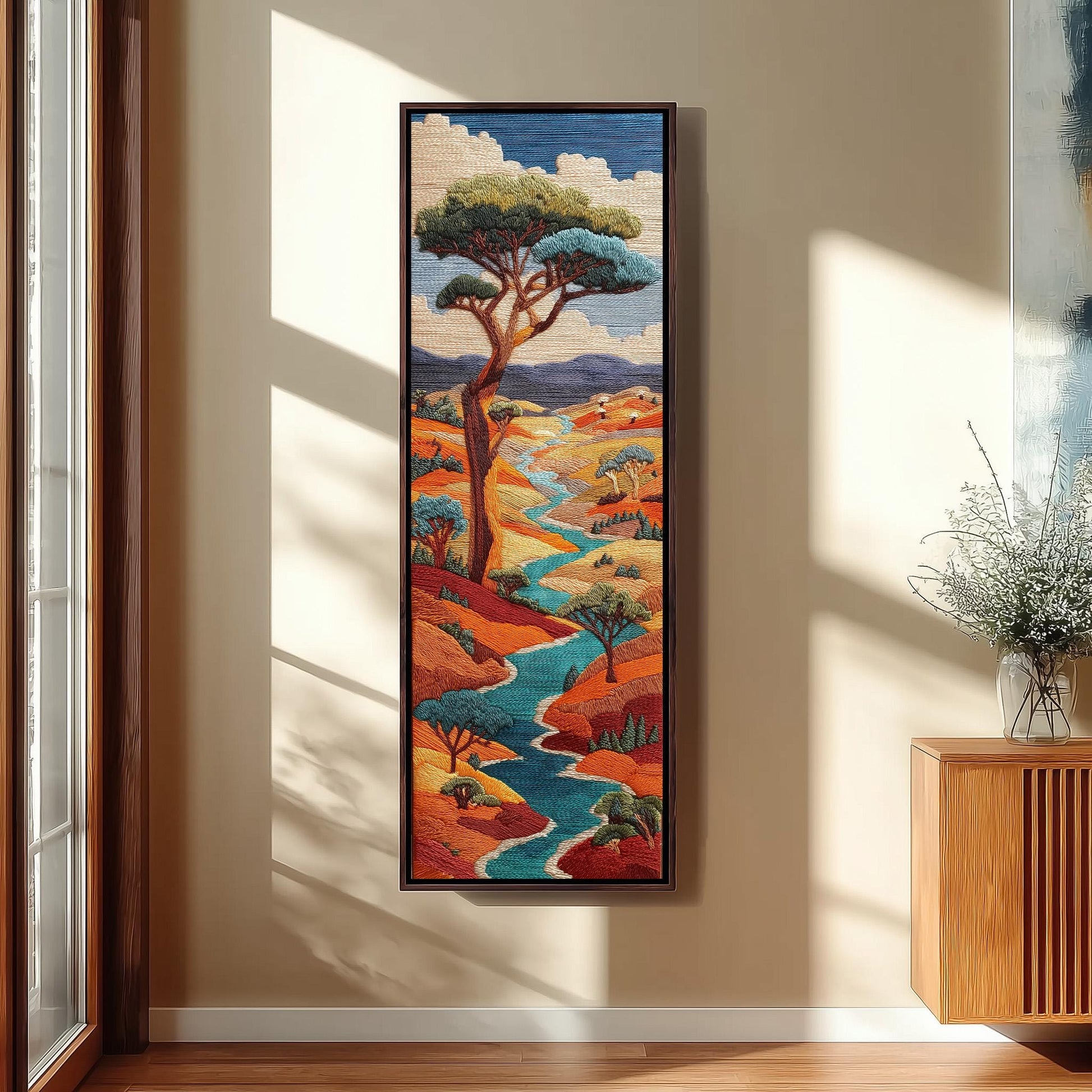 a large, colorful painting of a landscape with a winding river, trees, and mountains. The painting is hanging on a wall in a room with a wooden cabinet and a vase of flowers.