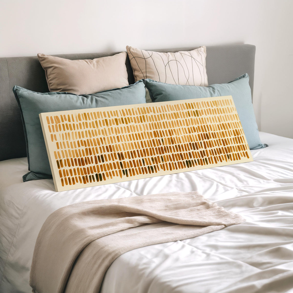 Brushmarks fading from cream to amber wide panoramic canvas print laid on a bed to show its size