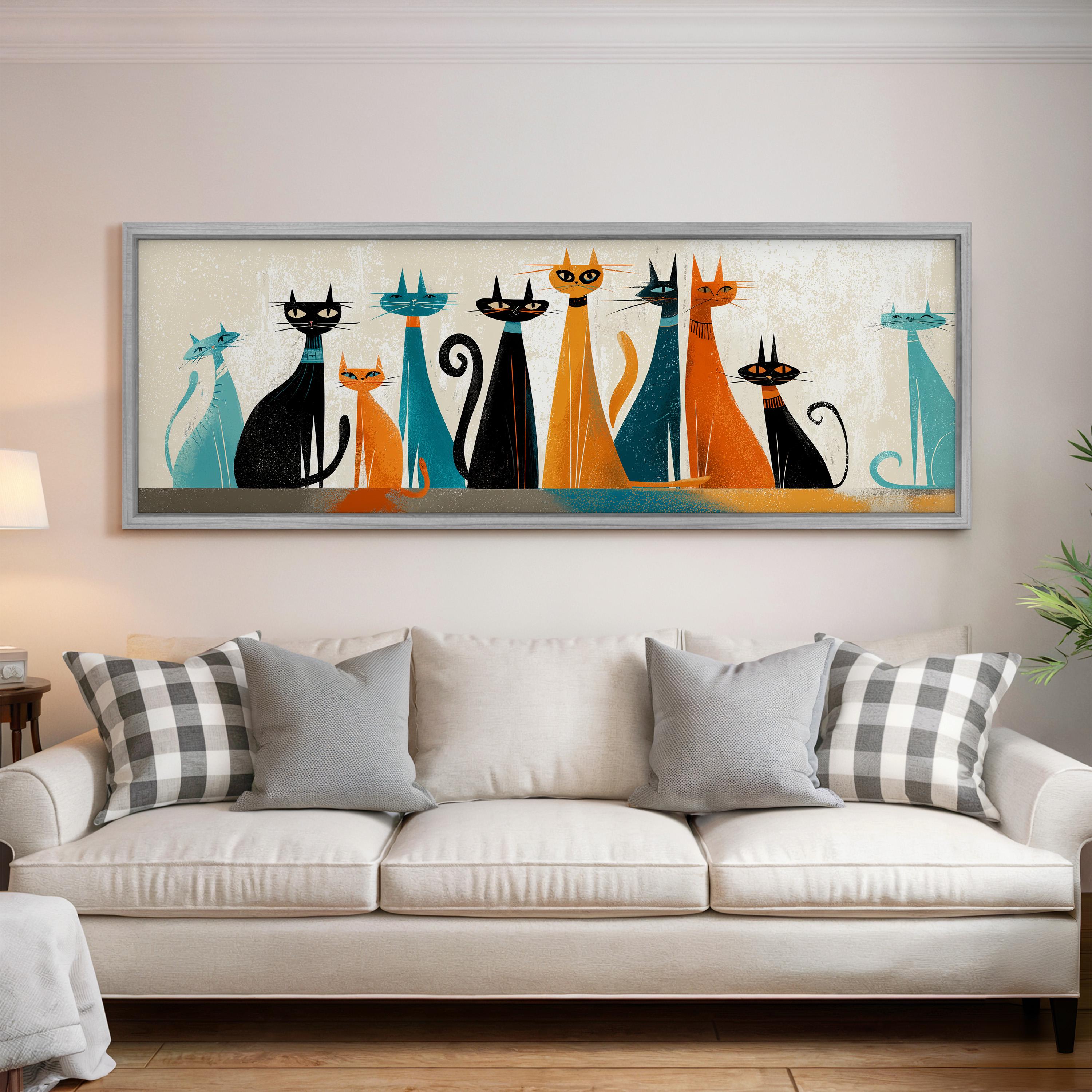 a large framed artwork of cats in various colors and poses, hanging on a wall above a white couch in a living room setting.