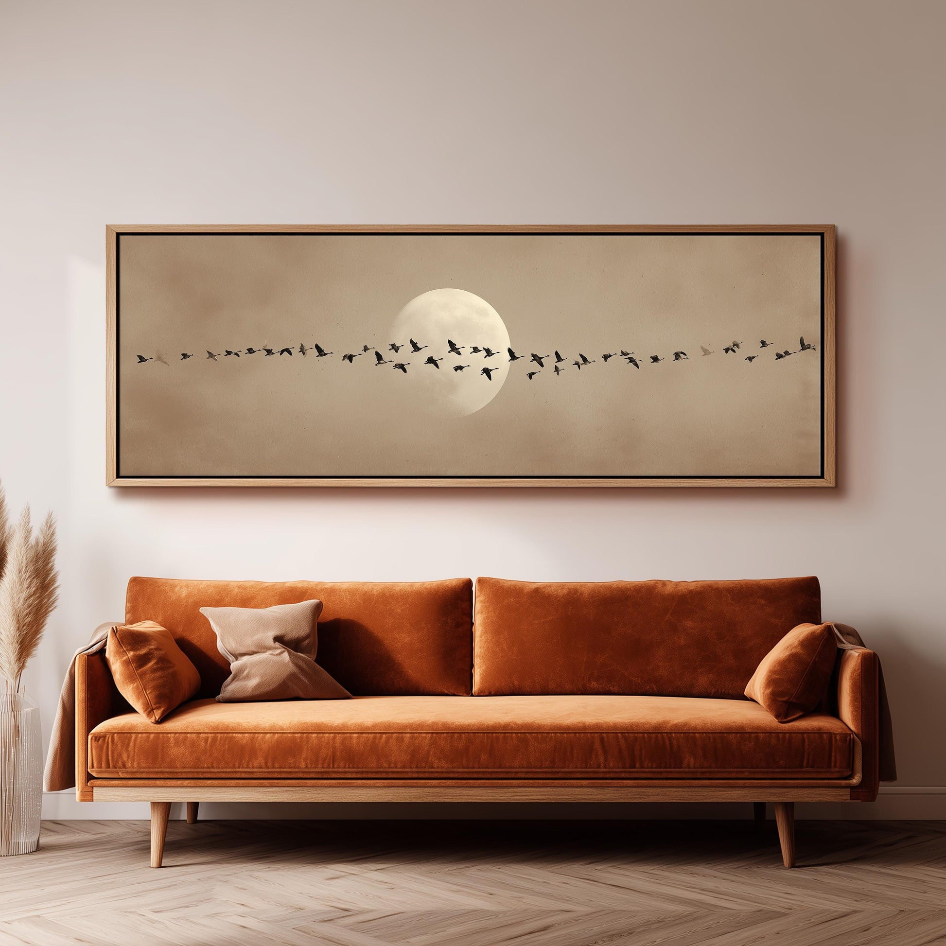 a large, framed painting of a flock of birds flying across the sky, with a full moon in the background.