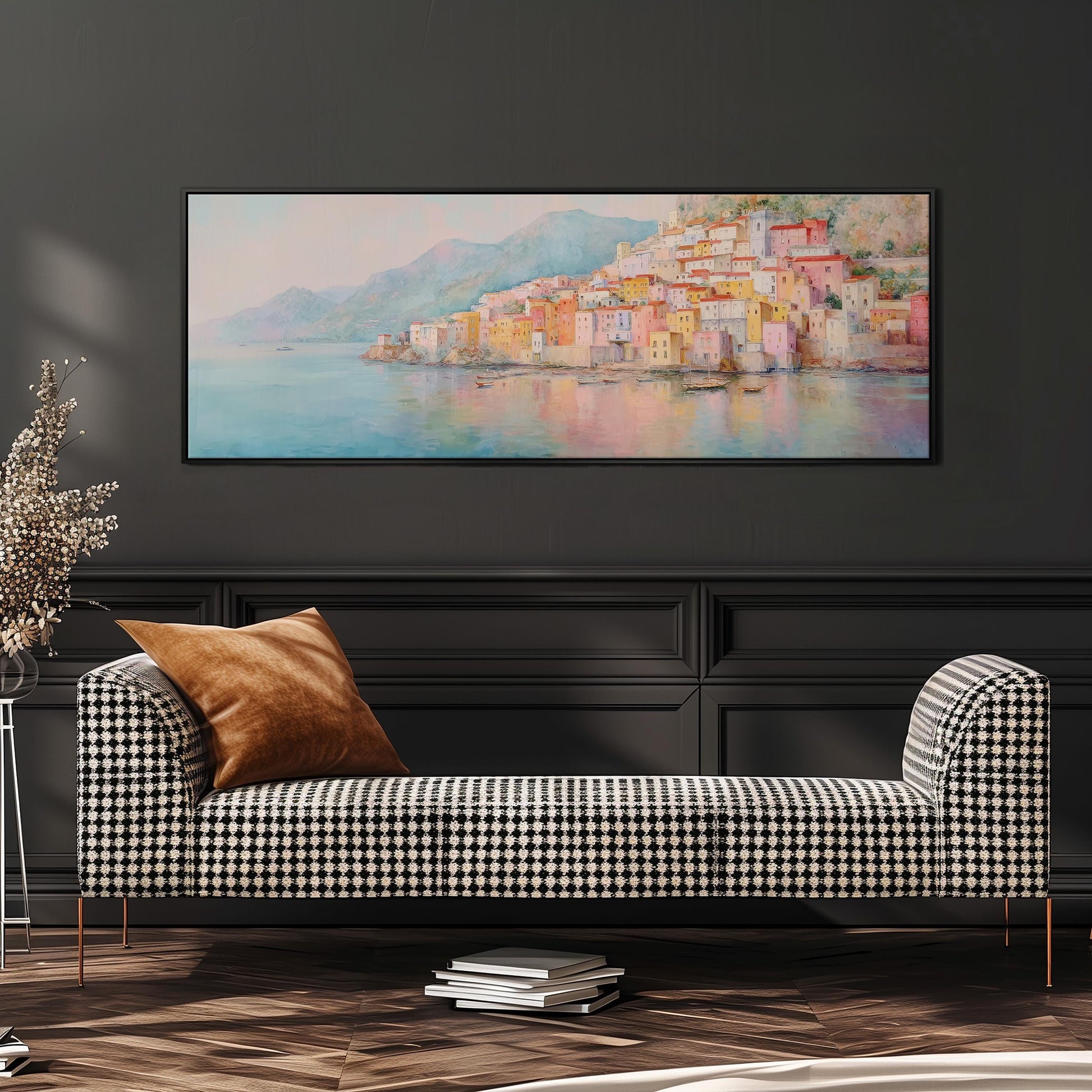 a large painting of a coastal town with colorful buildings, hanging on a wall above a black and white checkered sofa with a brown throw pillow.