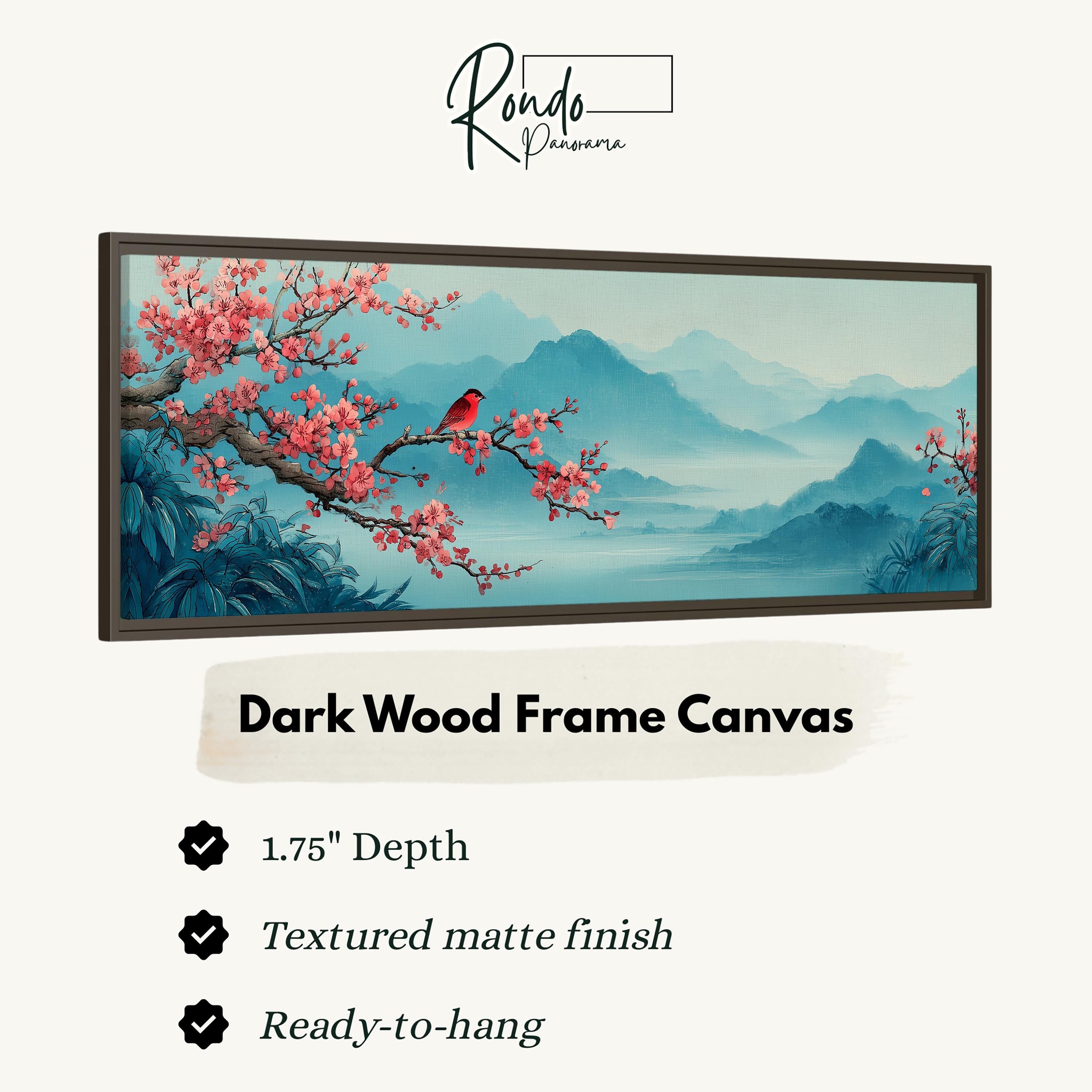 The image is a framed canvas depicting a serene landscape with a bird perched on a branch and pink flowers blooming on a tree. The frame is described as a "Dark Wood Frame Canvas" with a 1.75" depth, a textured matte finish, and a ready-to-hang feature.