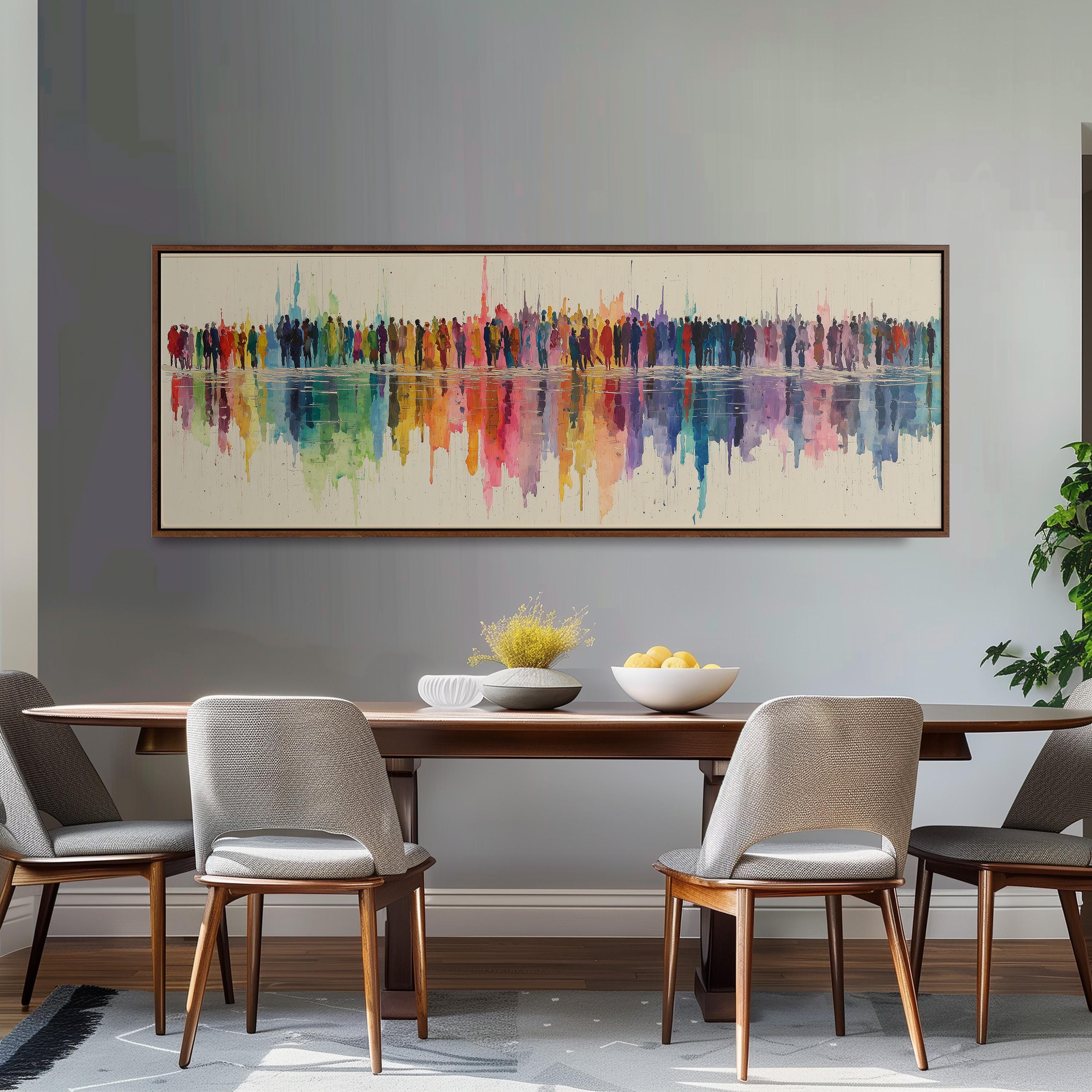 a dining room with a wooden table and four chairs. Above the table, there is a large painting depicting a colorful abstract scene with a long line of people. The painting is hanging on a gray wall, and the dining table is set with a bowl of fruit and a vase of flowers.