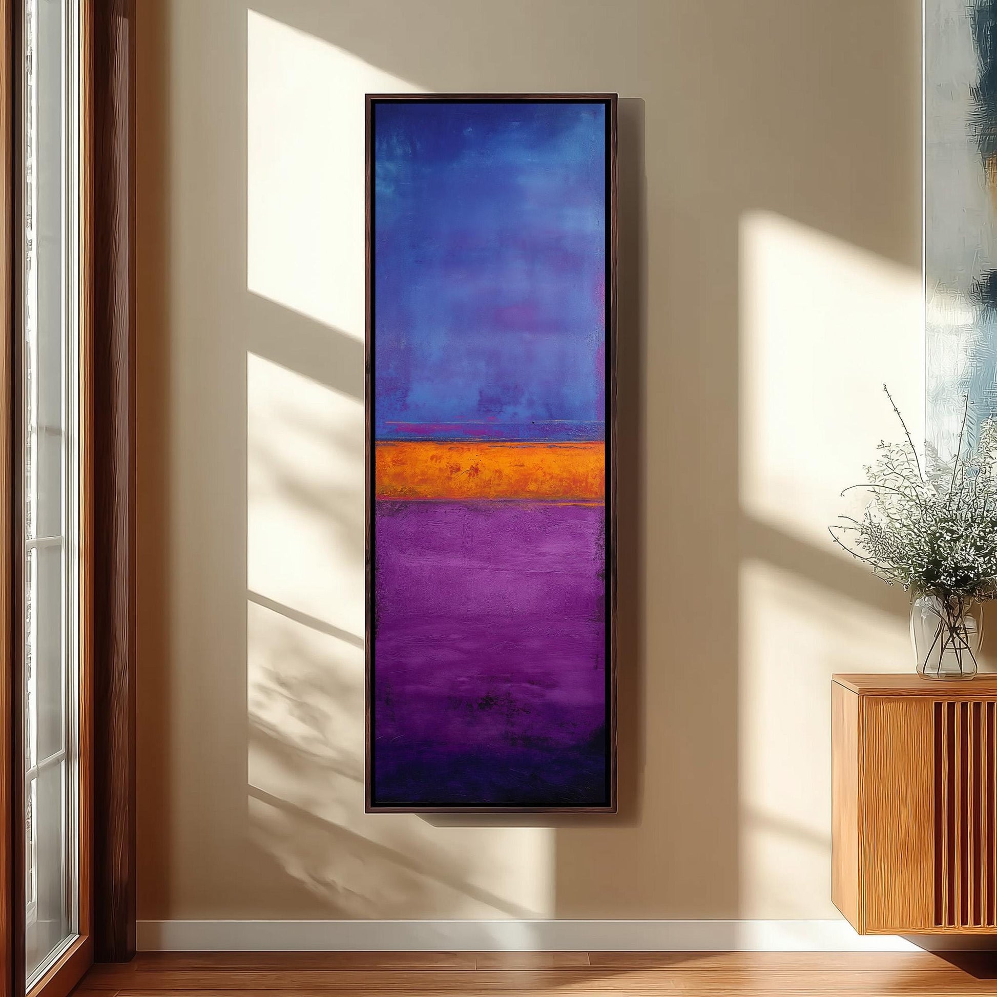 a large, colorful abstract painting hanging on a wall in a room with a wooden floor and a window.