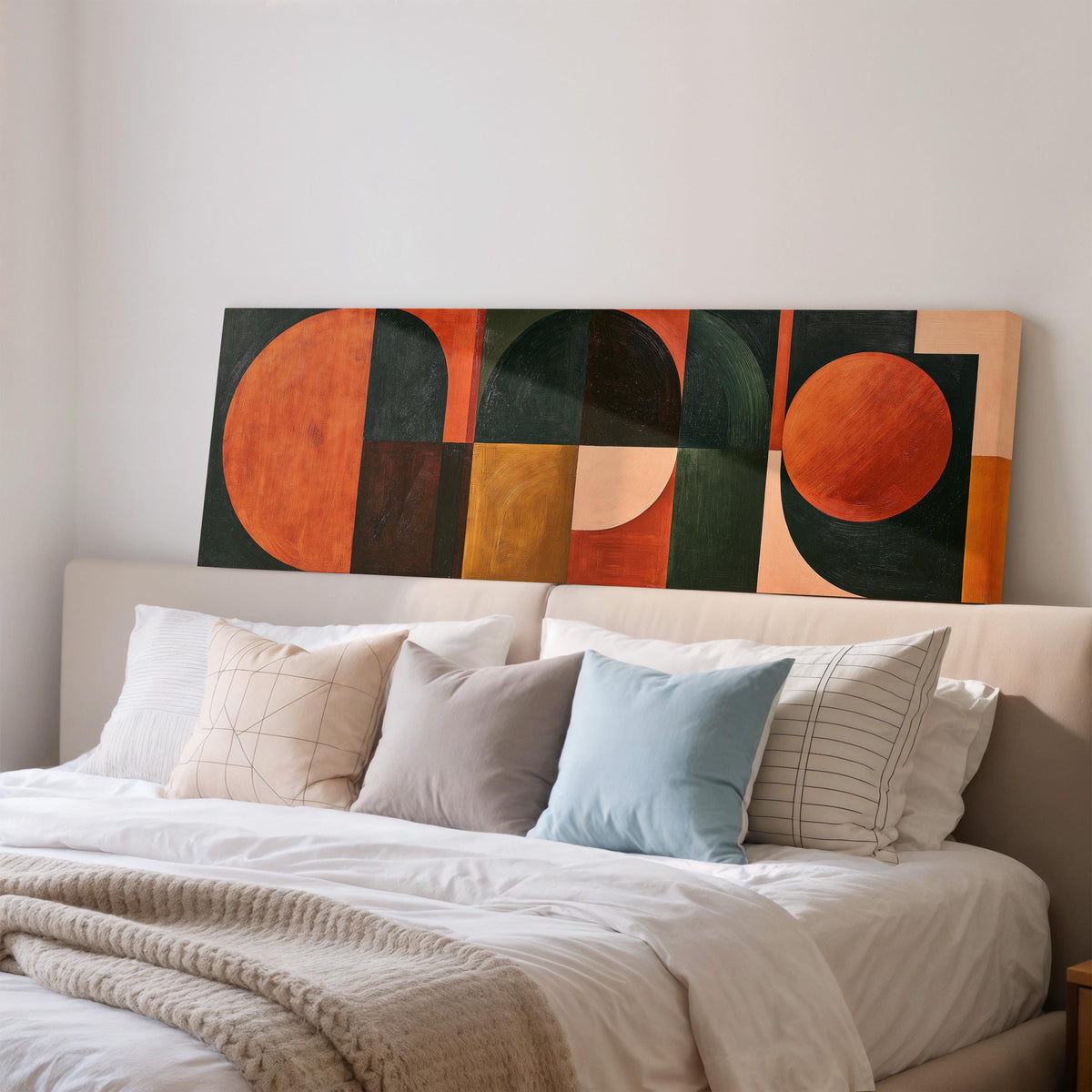 Orange circles and arches on forest green wide panoramic canvas print above a bed in a bedroom