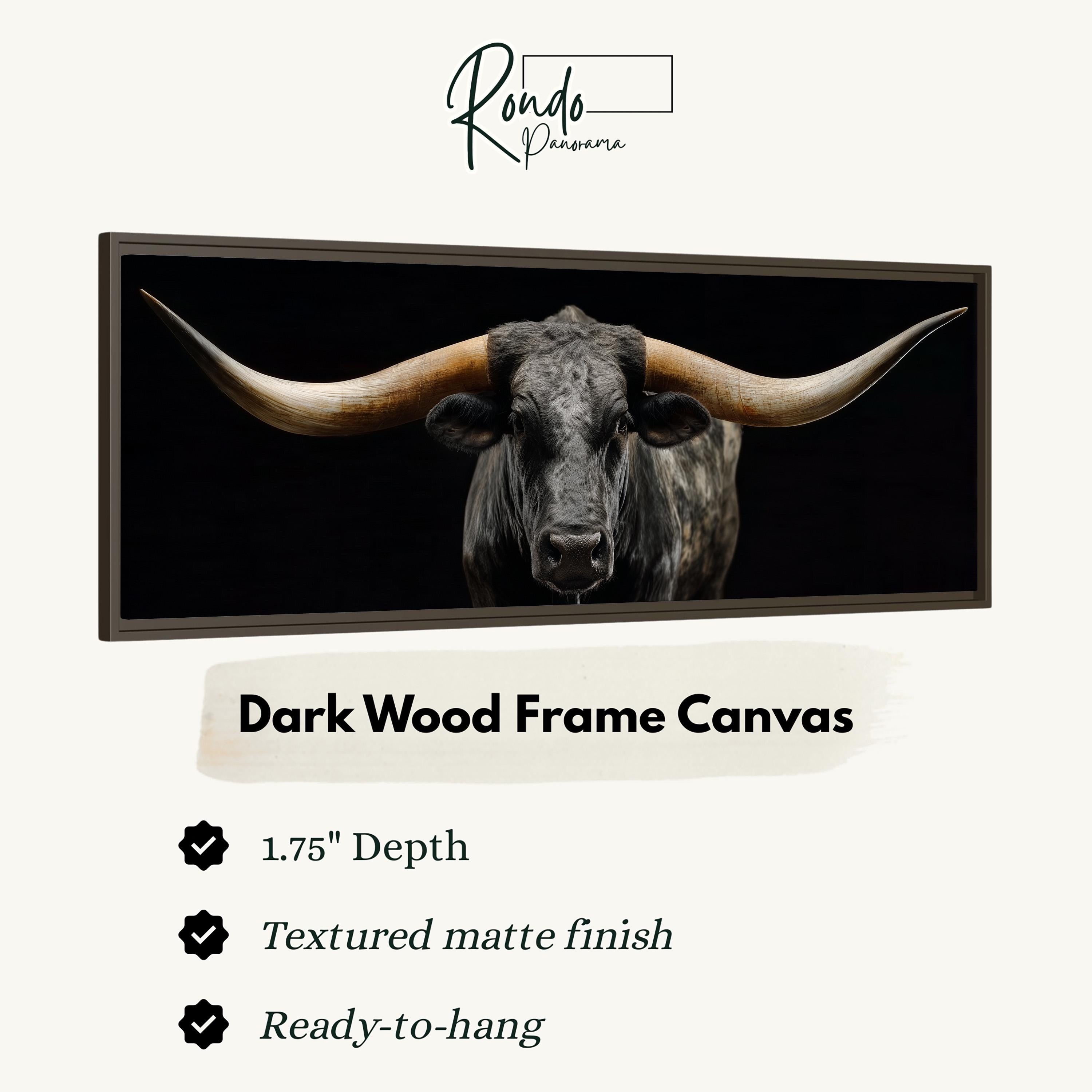 a close-up of a bull with large horns, displayed in a dark wood frame.