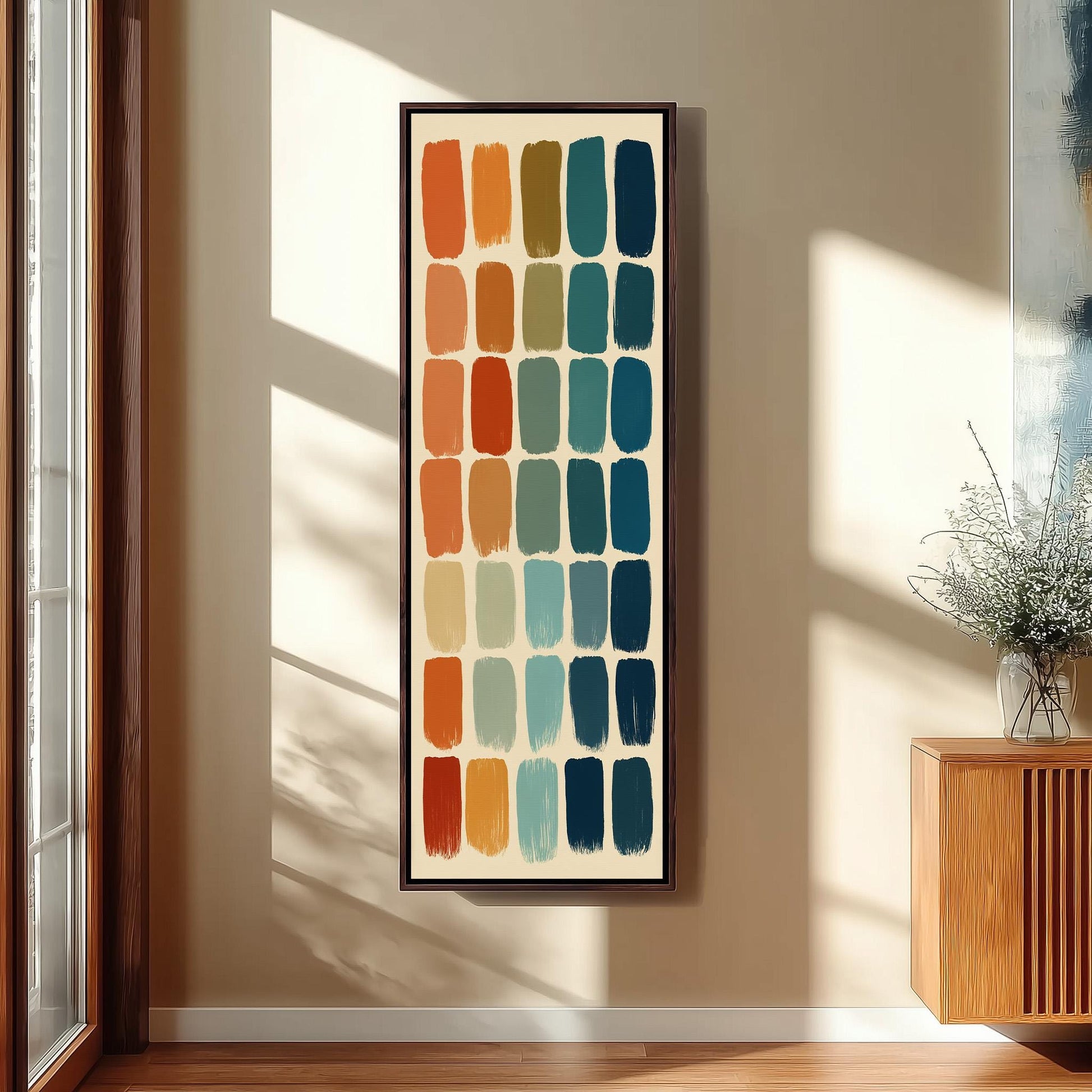 a large abstract painting hanging on a wall, with a wooden cabinet and a vase of flowers to the right of the painting.