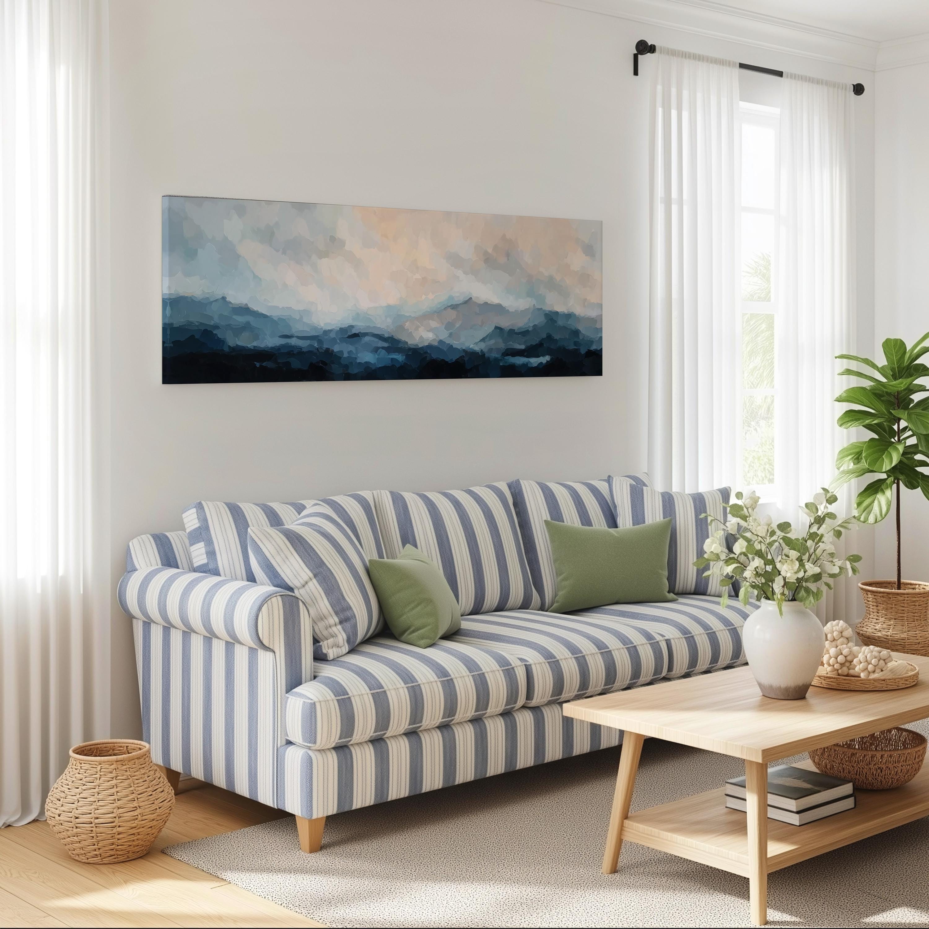 a cozy living room with a striped blue and white sofa, a wooden coffee table, and a large painting of a mountain landscape hanging on the wall.