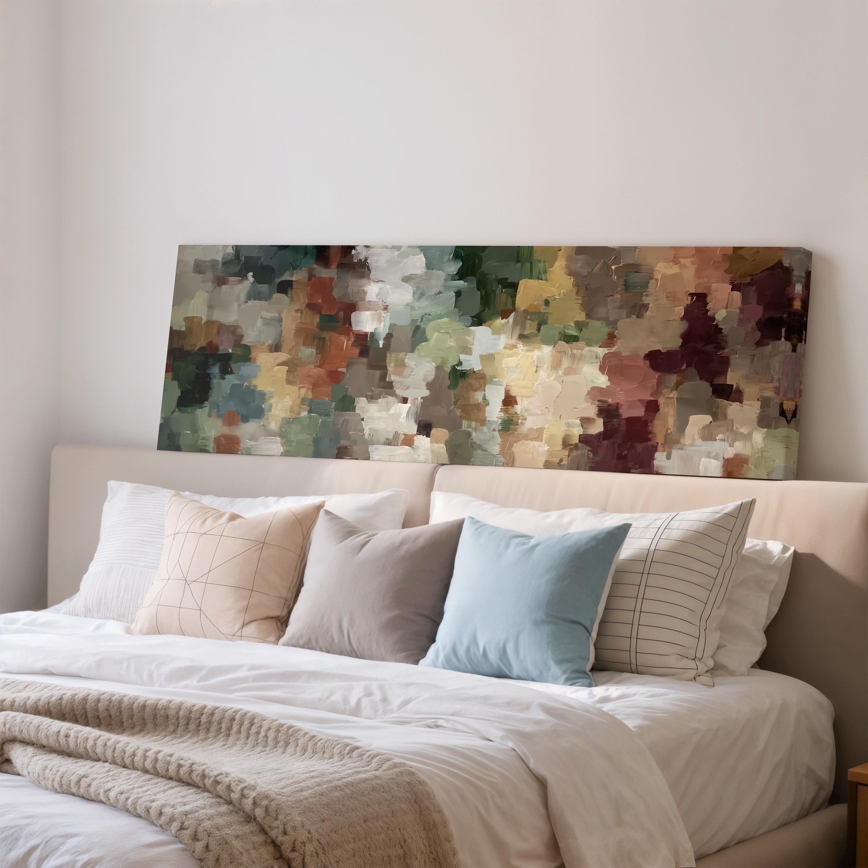 a cozy bedroom with a large bed adorned with white linens and colorful throw pillows. Above the bed, there is a large abstract painting on the wall, adding an artistic touch to the room.