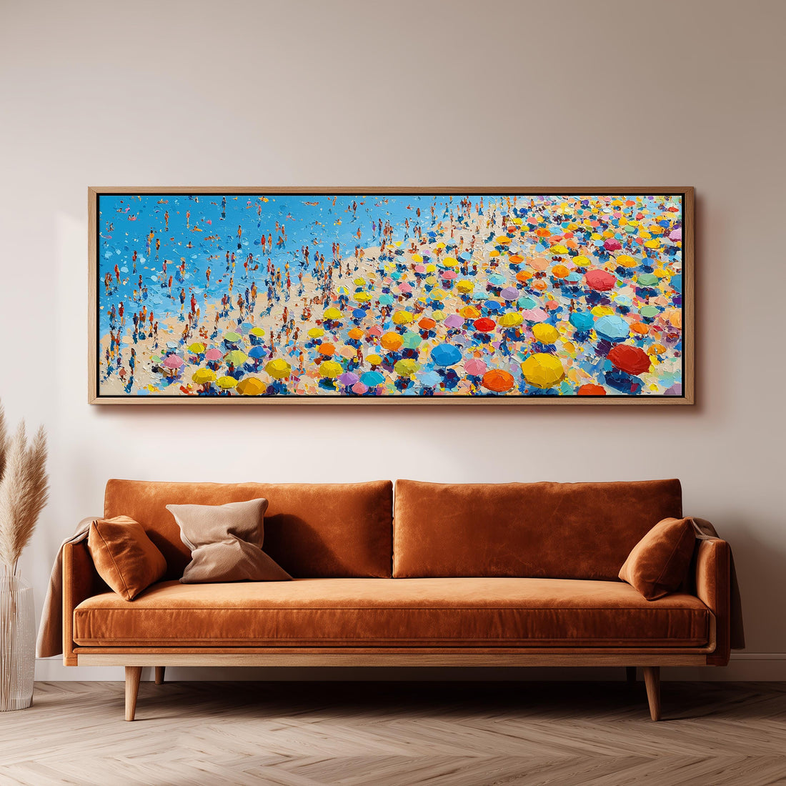 a large, colorful painting of a beach scene with many people and umbrellas, hanging on a wall above a brown sofa.