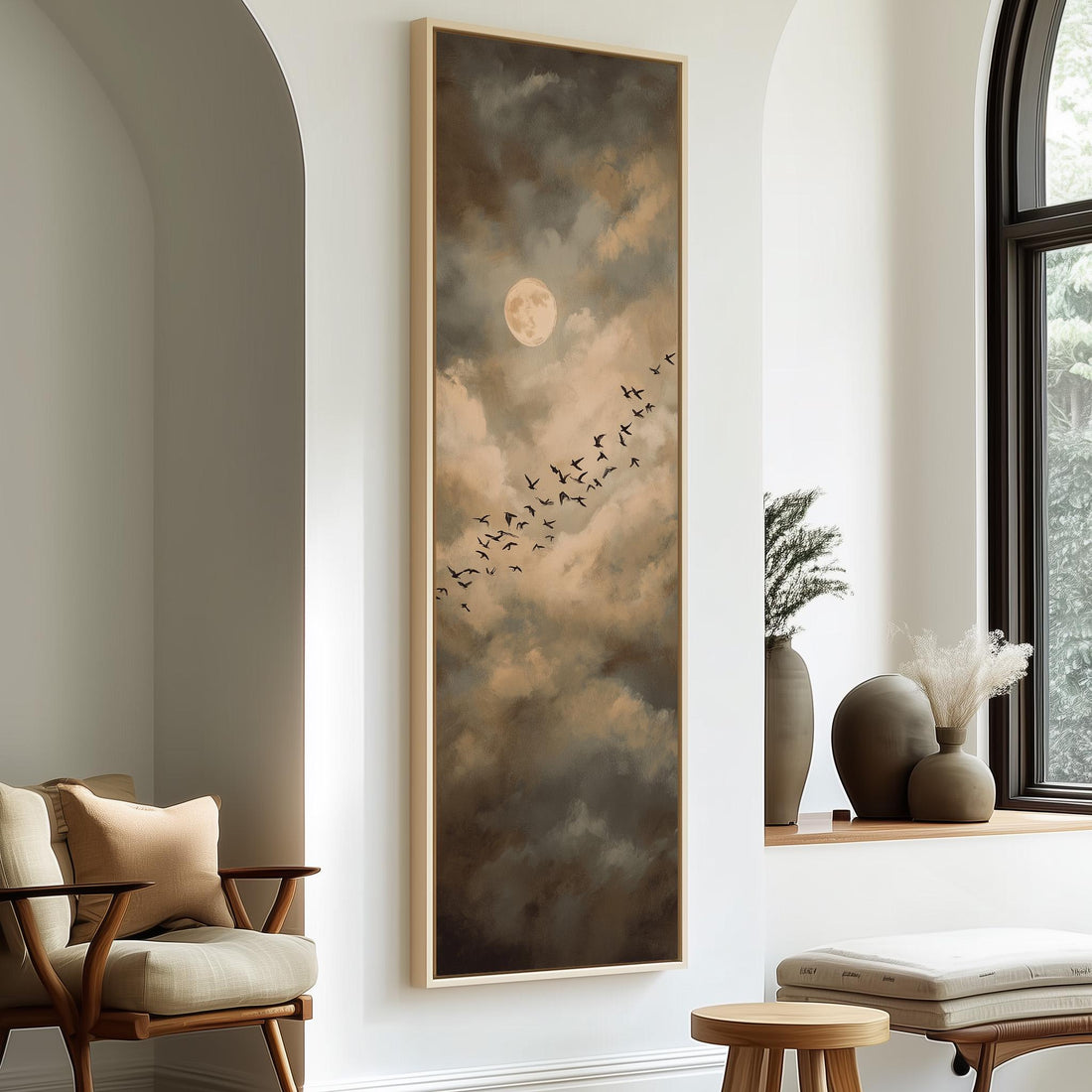 a large painting of a flock of birds flying across a cloudy sky, with a full moon in the background. The painting is mounted on a wall in a room with a window and a wooden chair.