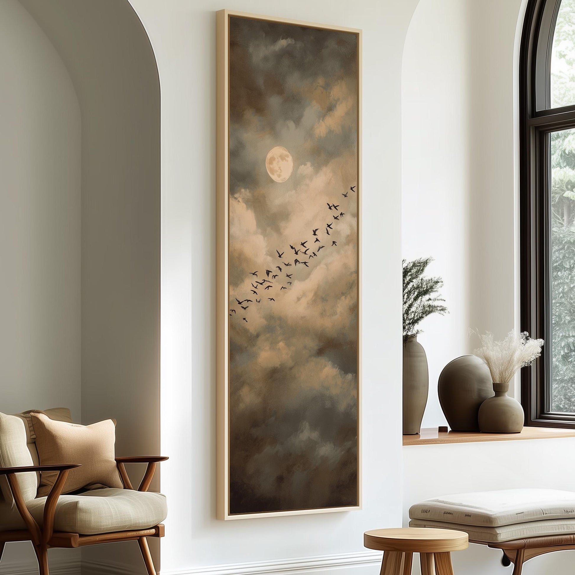 a large painting of a flock of birds flying across a cloudy sky, with a full moon in the background. The painting is mounted on a wall in a room with a window and a wooden chair.