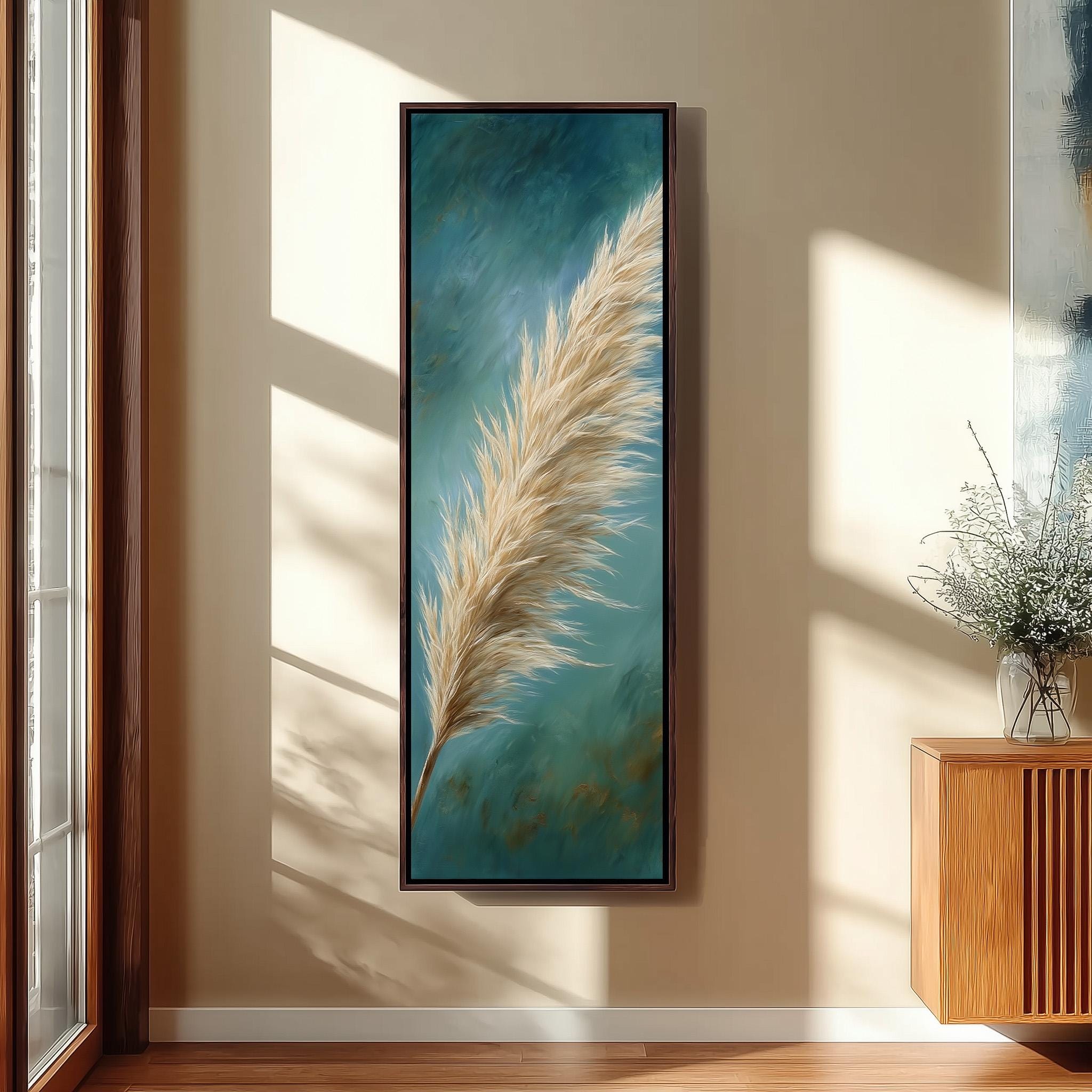 a large framed painting of a feather hanging on a wall in a room with a wooden cabinet and a vase of flowers.