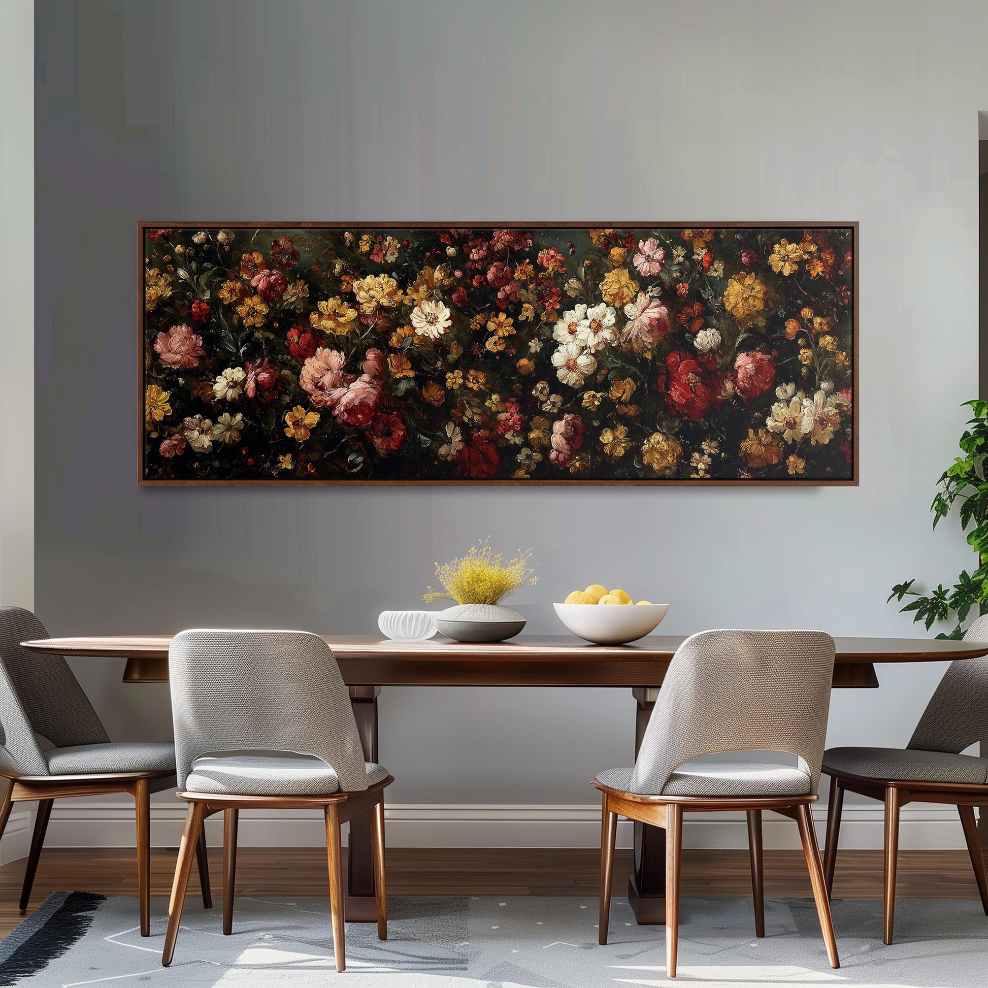 a dining room with a large floral painting hanging on the wall above a wooden table with four chairs. The table is set with a bowl of fruit and a vase of flowers, creating a cozy and inviting atmosphere.