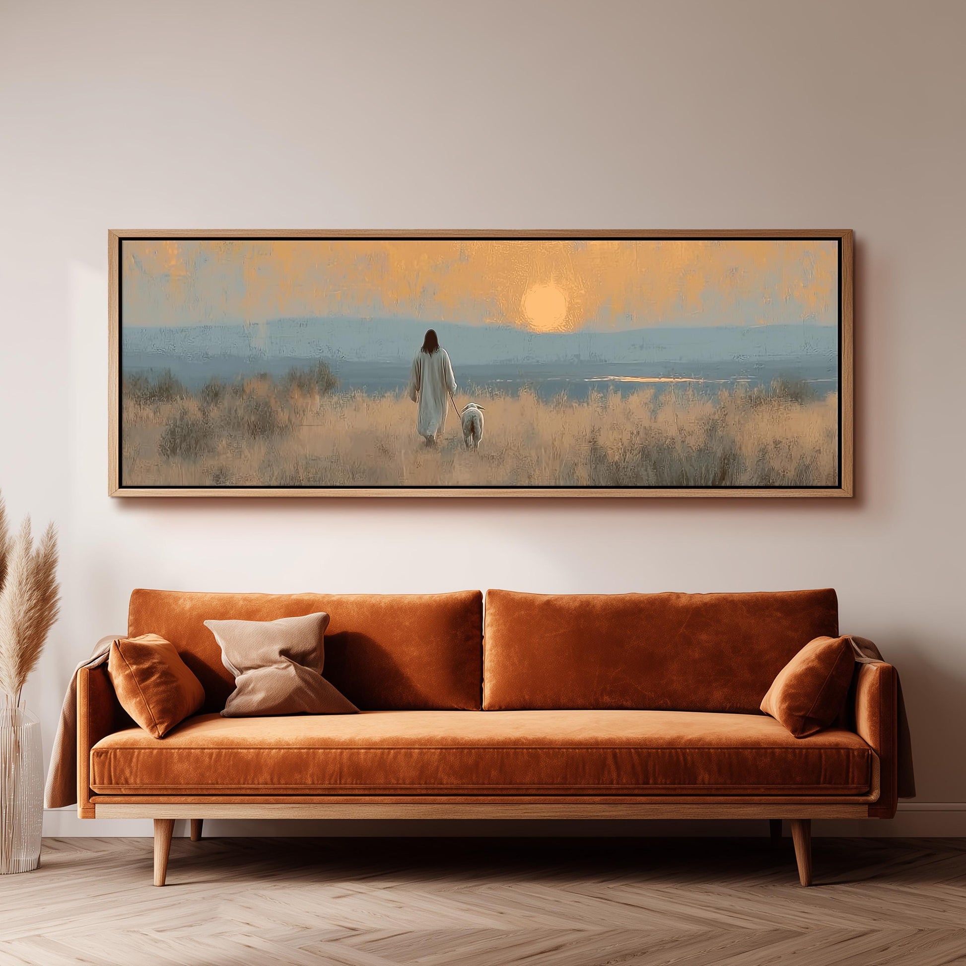 a large, rectangular painting hanging on a wall above a brown sofa. The painting depicts a person walking a dog in a field with a sunset in the background.