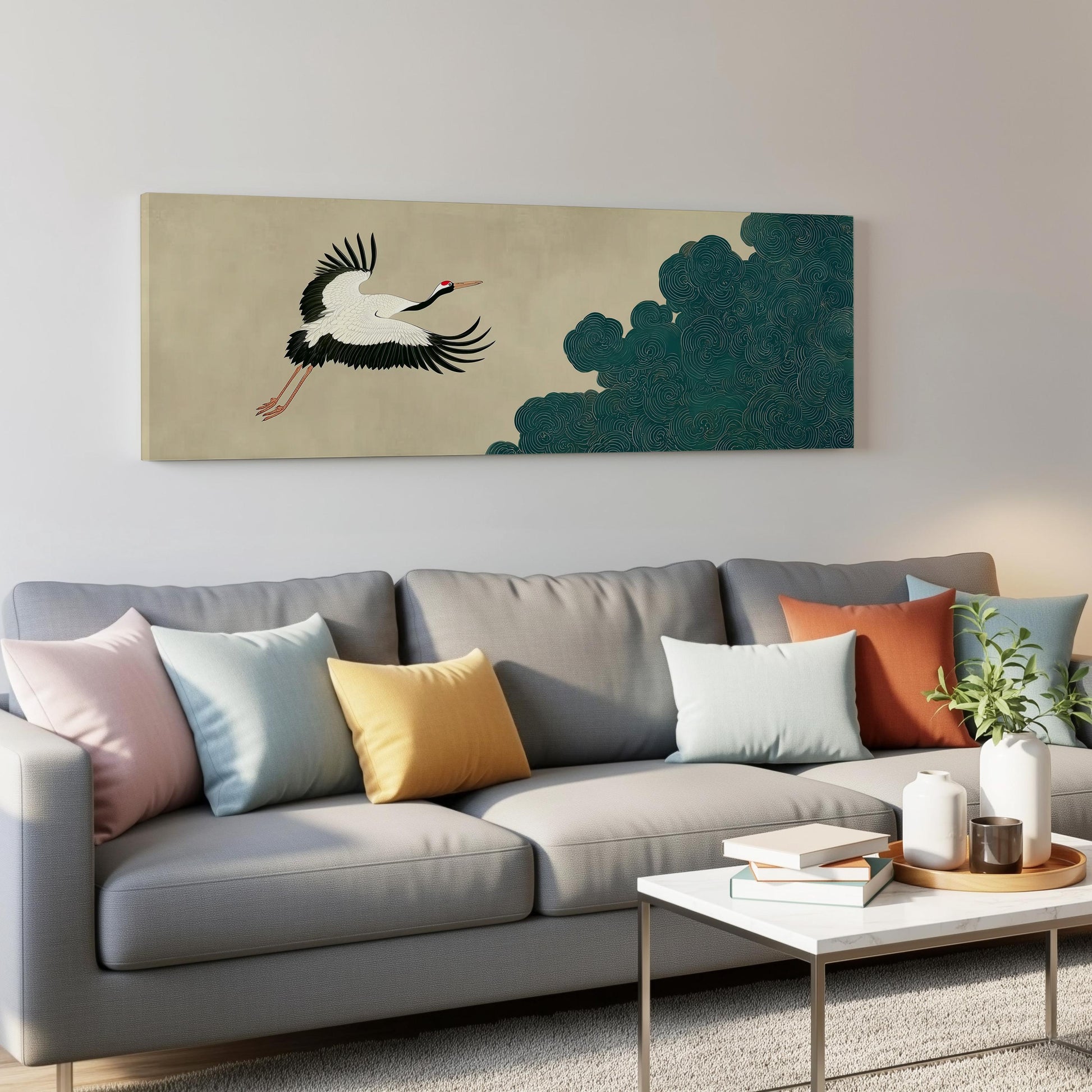 a gray couch with colorful throw pillows, a coffee table, and a large wall art depicting a crane in flight.