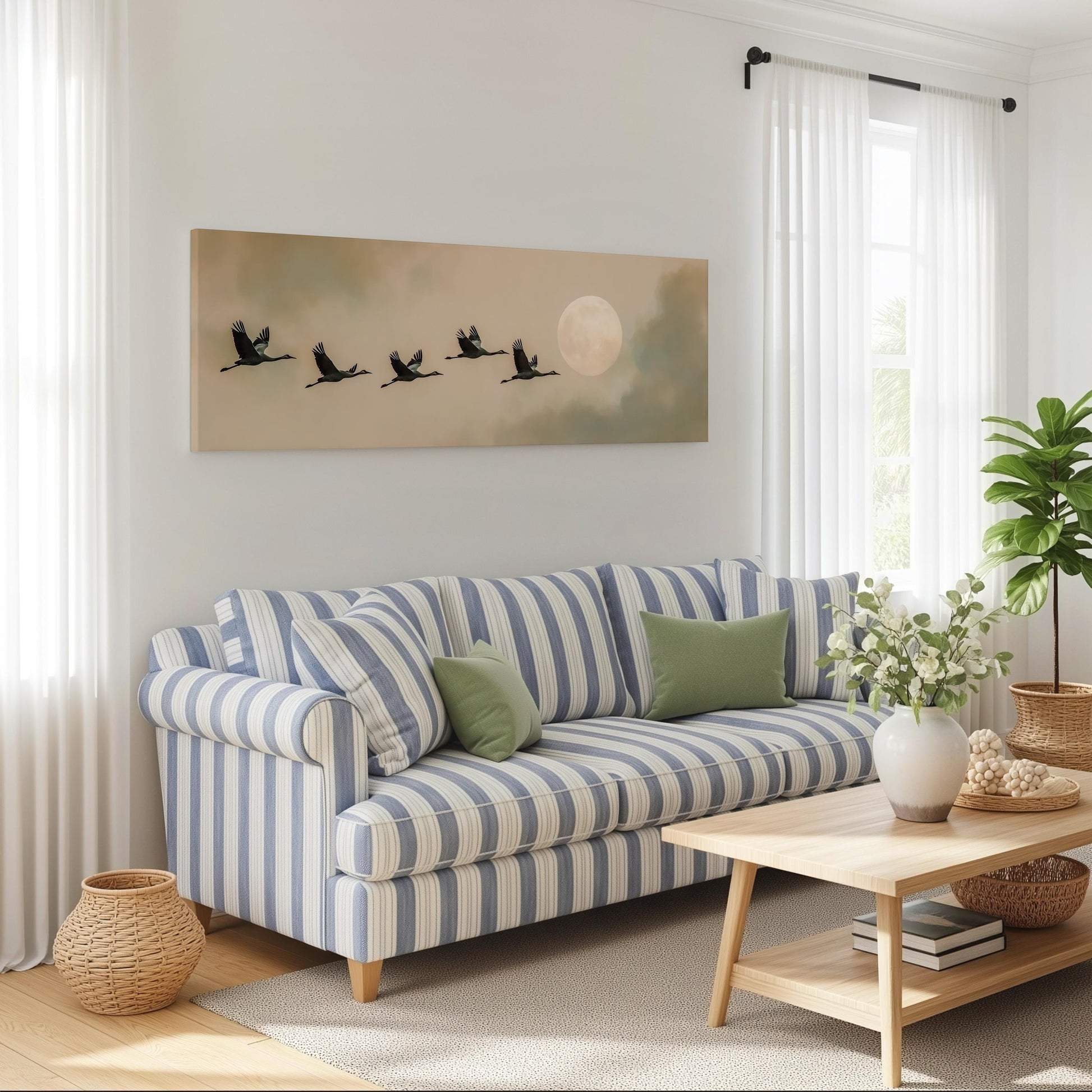 a cozy living room with a striped blue and white sofa, a wooden coffee table, and a large window with white curtains. Above the sofa, there is a painting of a flock of birds flying in formation, with a full moon in the background.