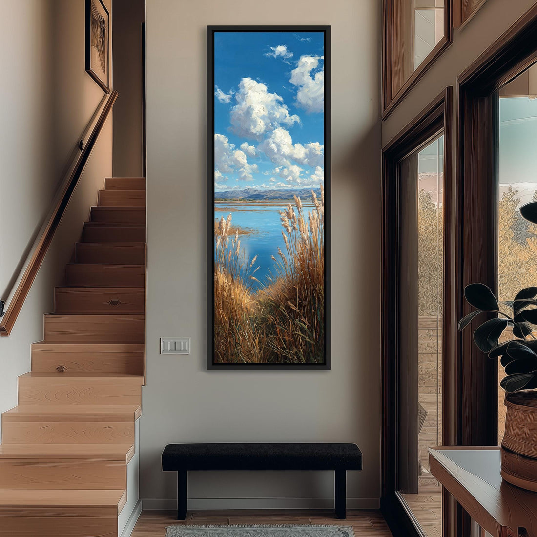 a large framed painting hanging on a wall, depicting a serene landscape with a body of water, mountains, and a sky filled with clouds.