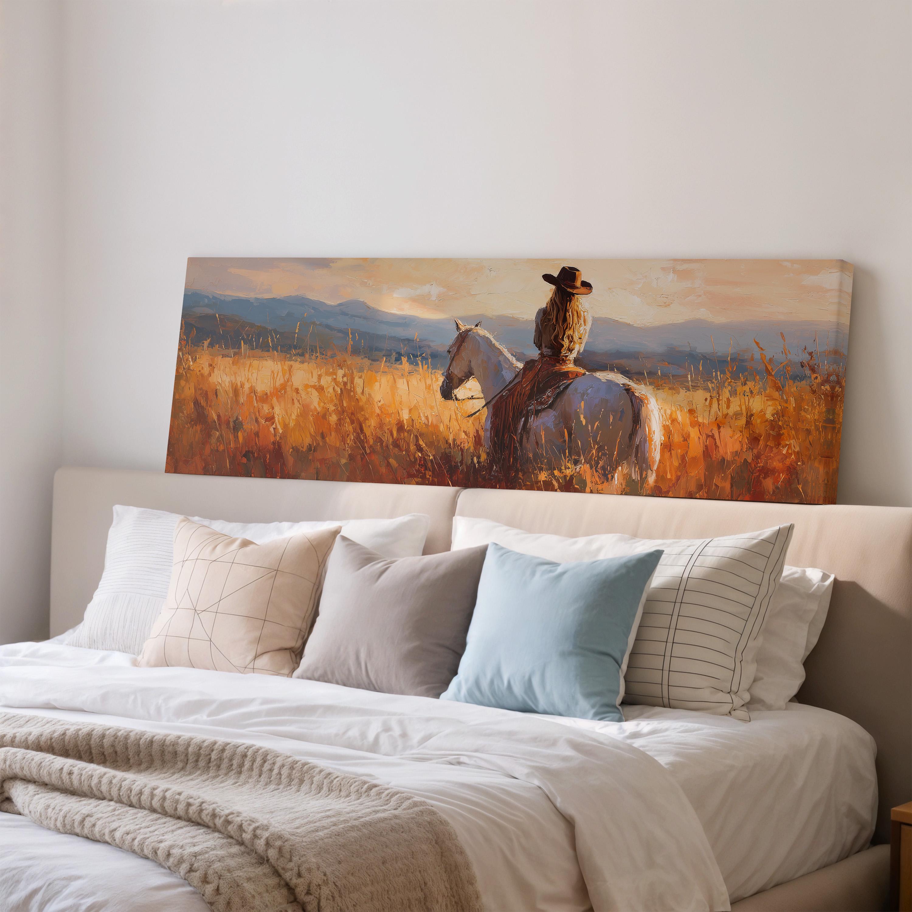 a large painting of a cowboy riding a horse in a field, with mountains in the background.