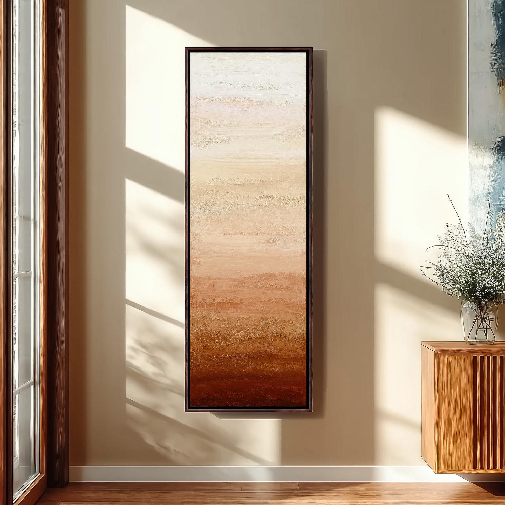 a large, rectangular painting hanging on a wall in a room with a wooden cabinet and a vase of flowers.