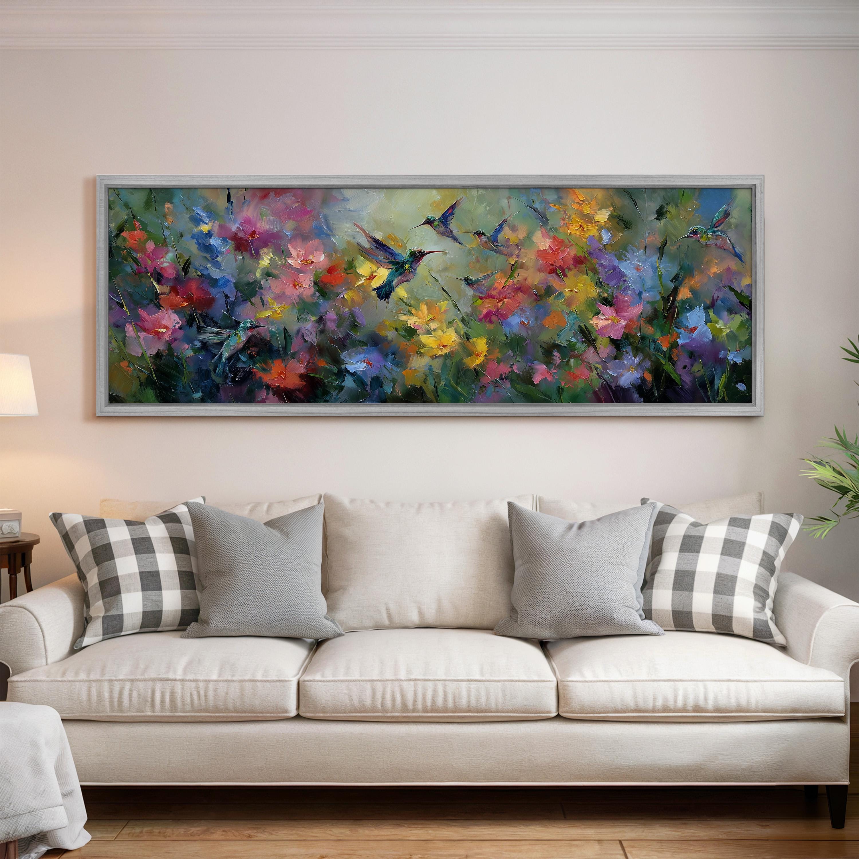 a large, colorful painting of flowers hanging on a wall above a white couch with gray and black plaid throw pillows.