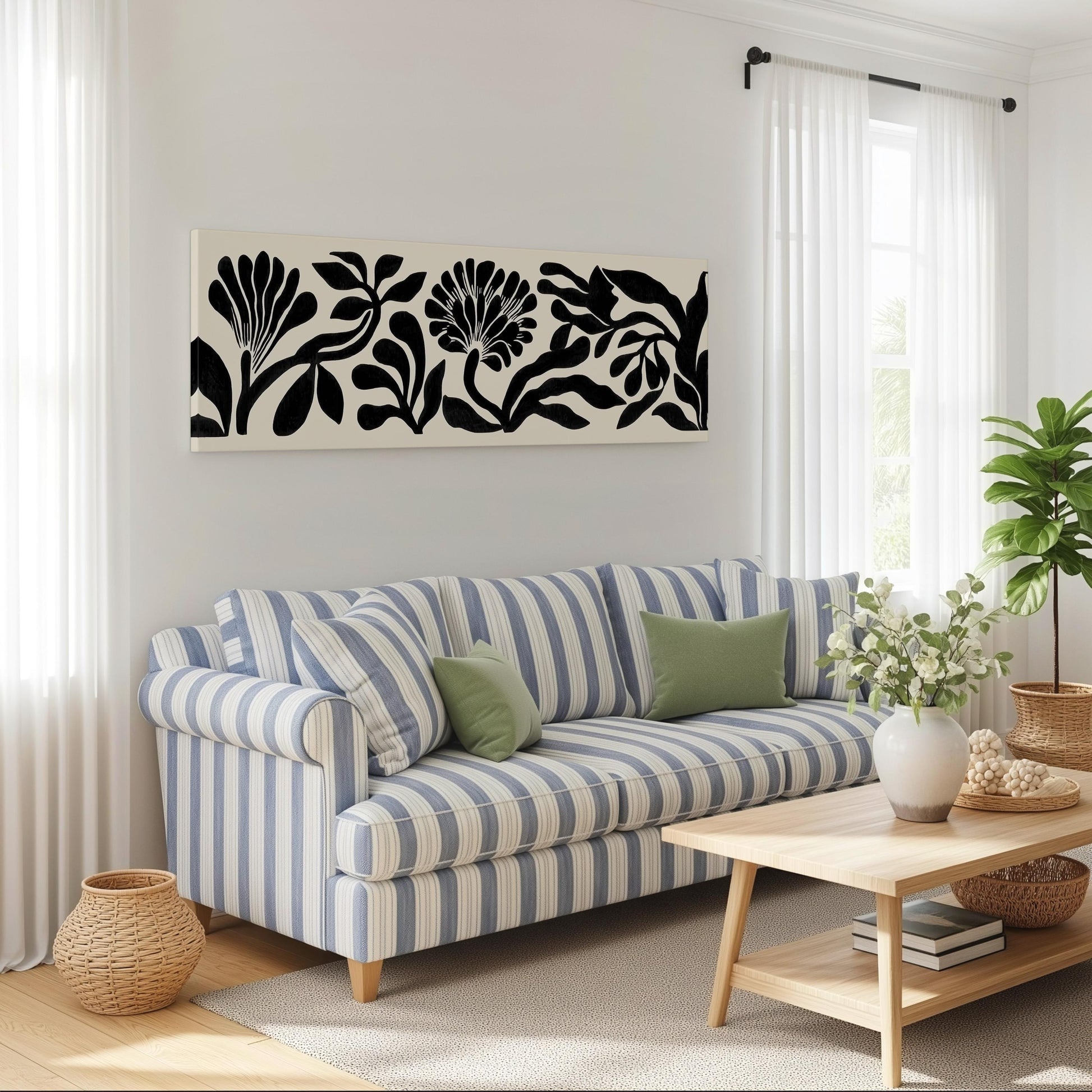 a cozy living room with a striped blue and white sofa, a wooden coffee table, and a large black and white floral artwork hanging on the wall above the sofa.