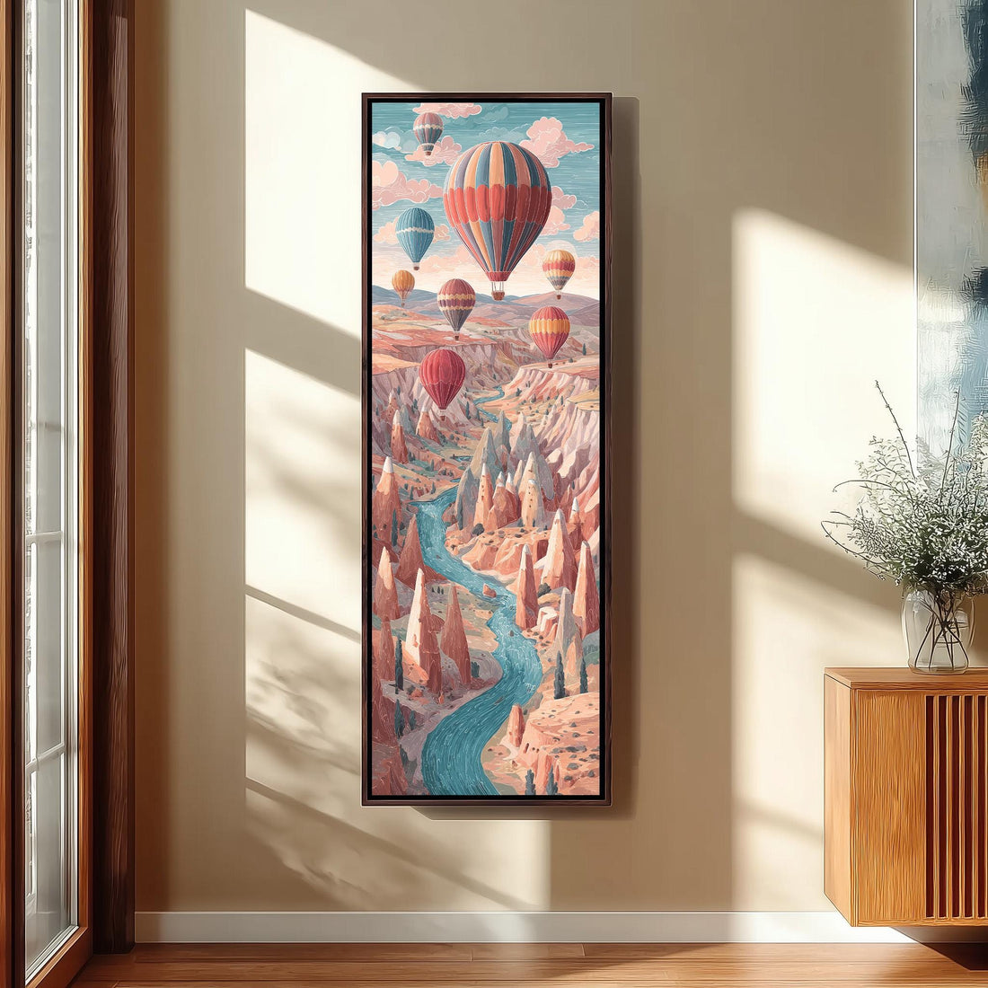 a large, colorful painting of hot air balloons floating over a mountainous landscape, hanging on a wall in a room with a bed, a potted plant, and a woven ottoman.