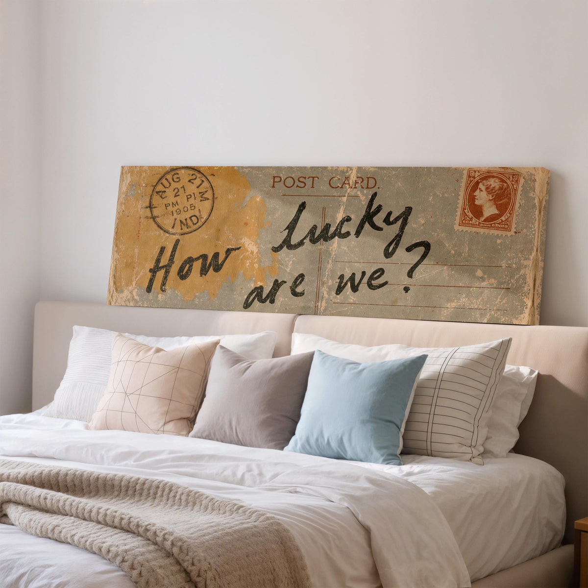 Vintage postcard saying how lucky are we wide panoramic canvas print above a bed in a bedroom