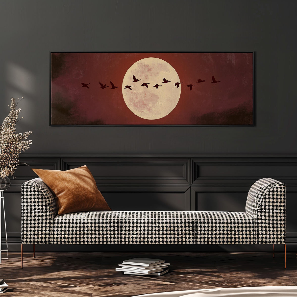 Geese crossing a pale moon on maroon wide panoramic canvas print above a bench in a dark living room