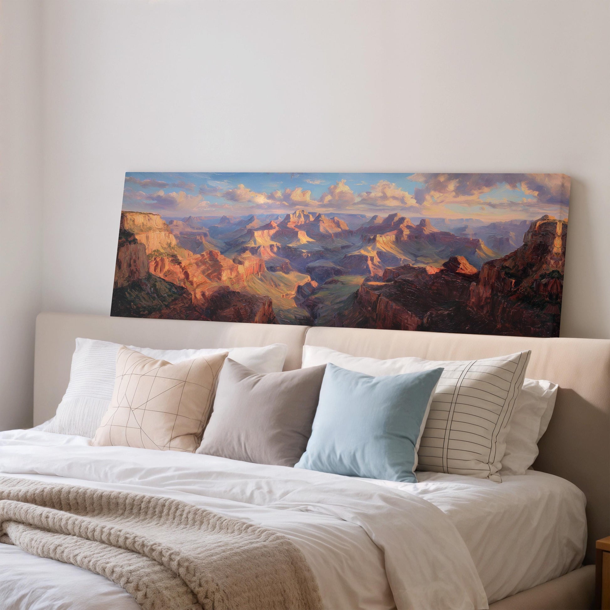 a large painting of a scenic mountain landscape hanging on a wall above a bed with white bedding and pillows.