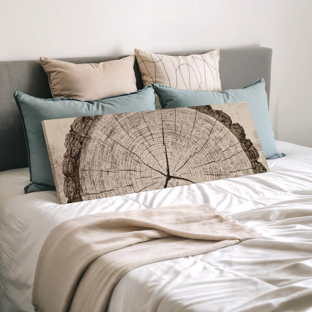 Sepia tree ring with radial cracks wide panoramic canvas print laid on a bed to show its size