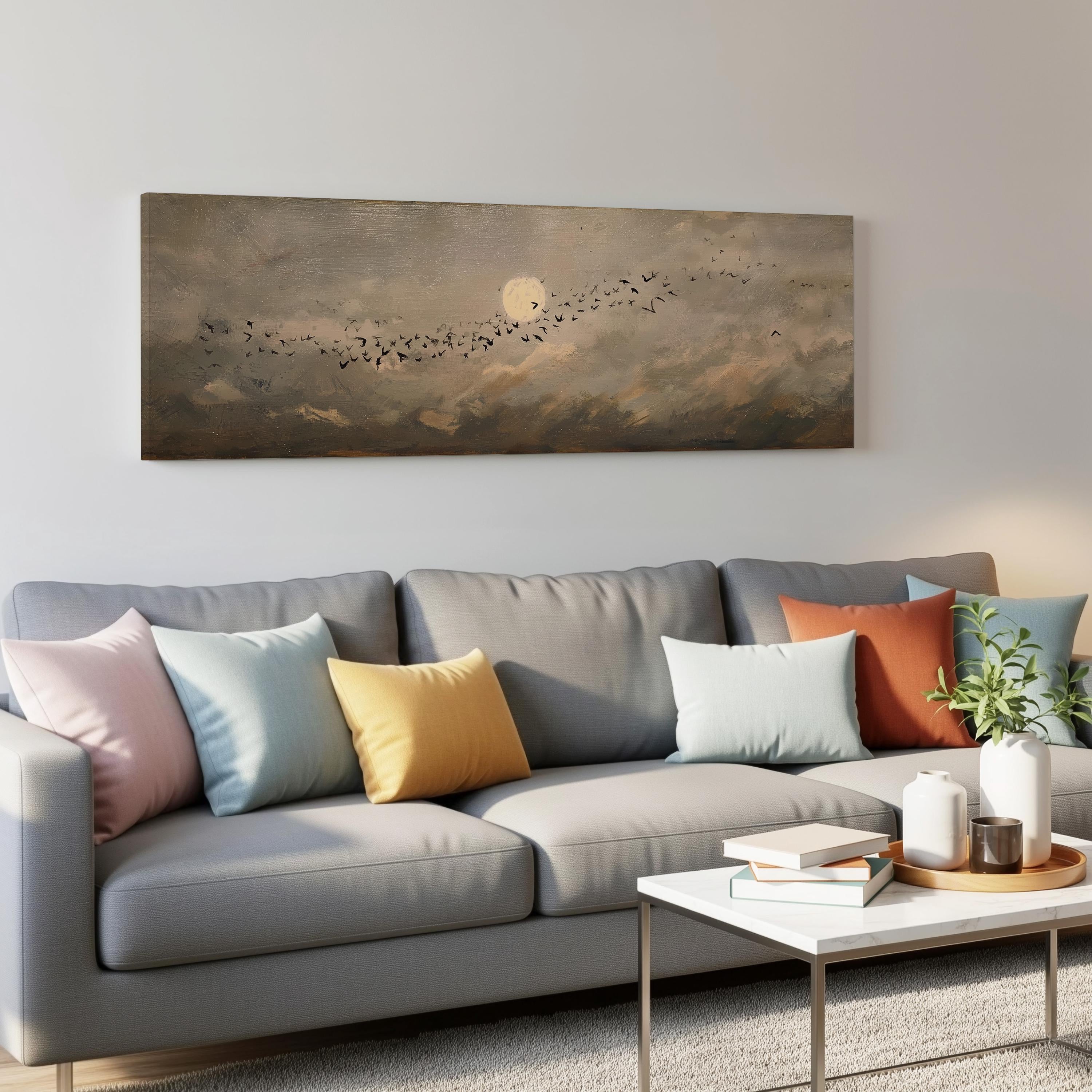 a gray couch with colorful throw pillows, a coffee table, and a painting of a flock of birds in the sky above it.
