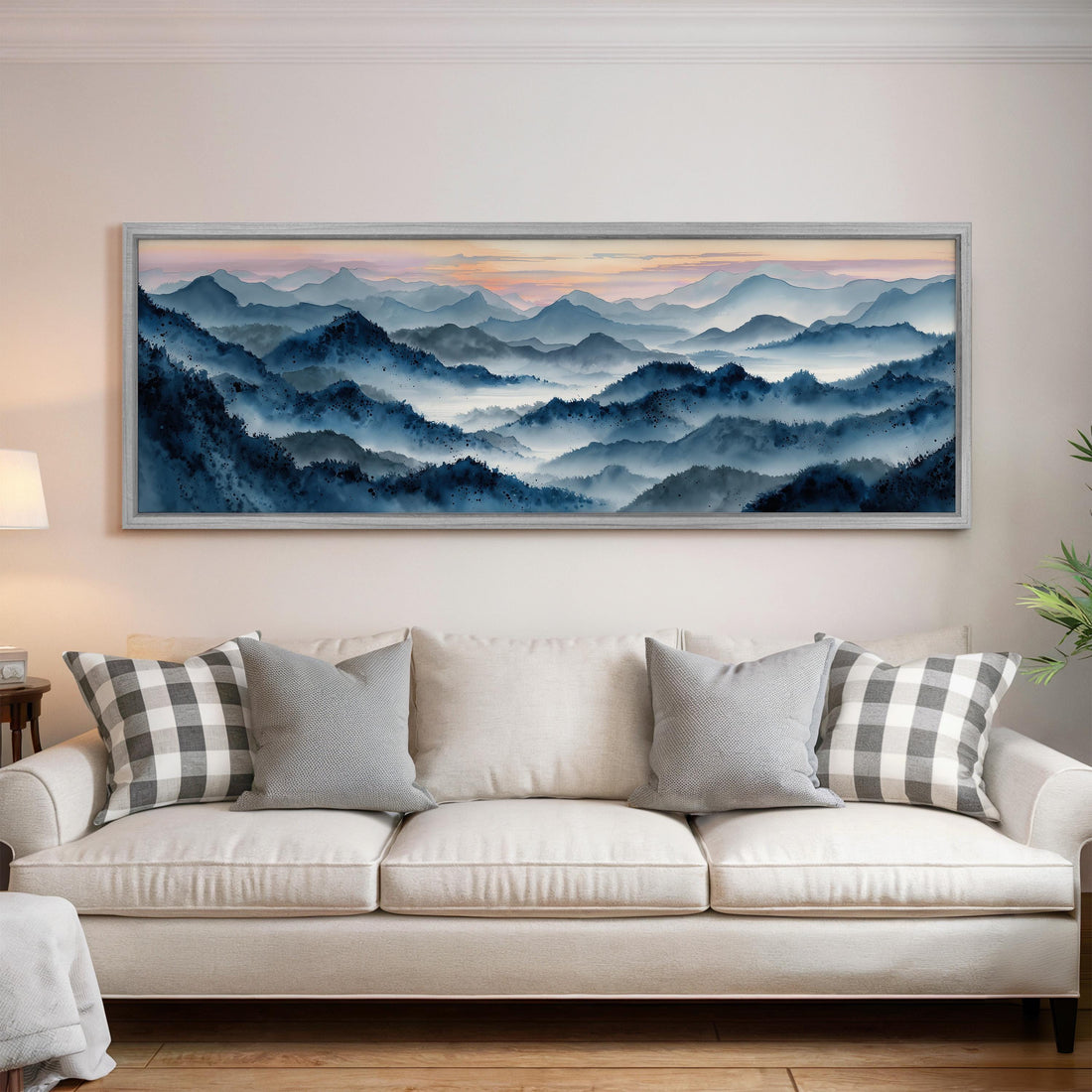 a large, framed landscape painting hanging on a wall above a black and white checkered sofa in a living room setting.