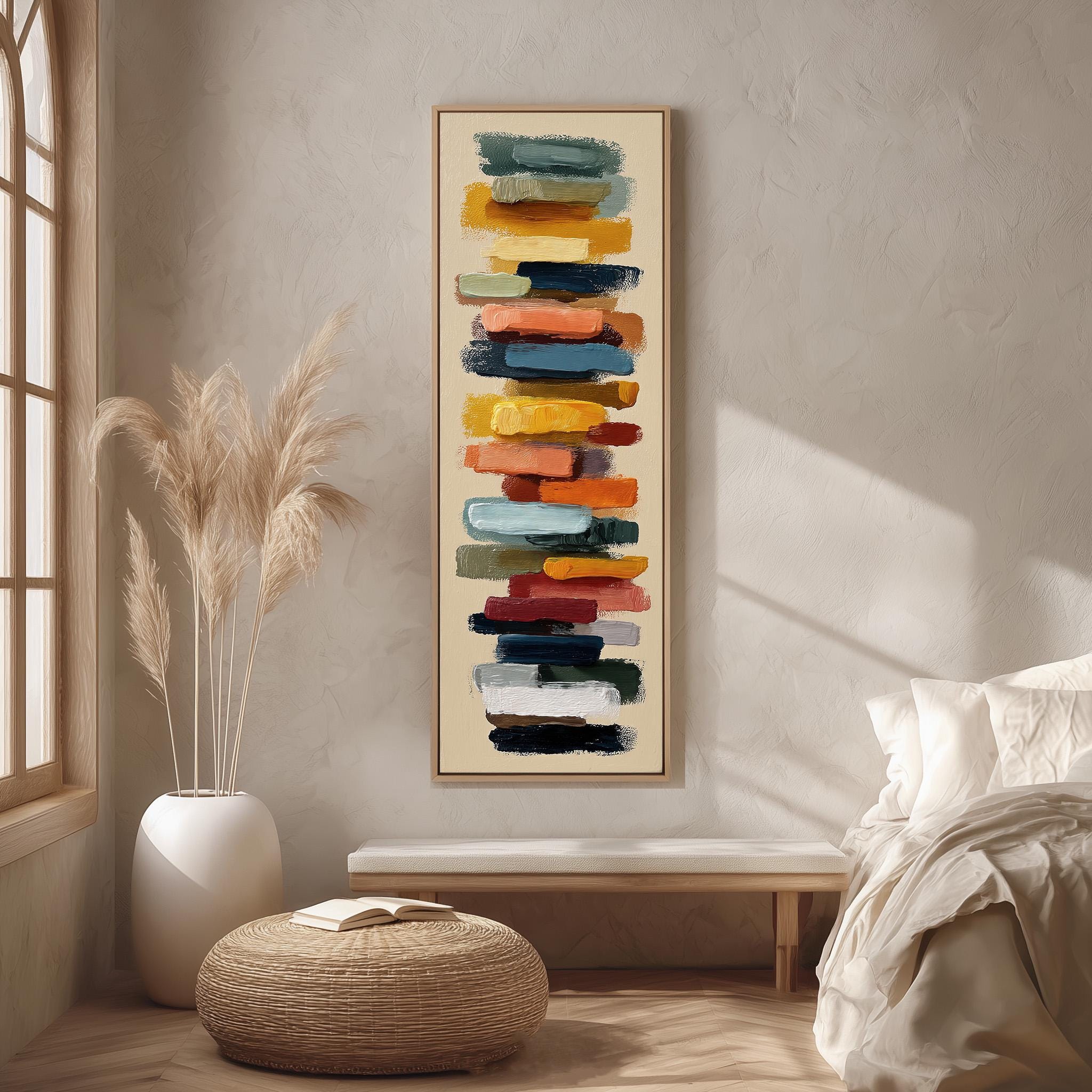 a modern bedroom with a large abstract painting hanging on the wall above a wooden bench. The painting consists of a series of colorful brushstrokes arranged vertically, creating a dynamic and visually striking display. The room is decorated with a large window, a potted plant, and a woven ottoman, contributing to the overall contemporary and minimalist aesthetic.