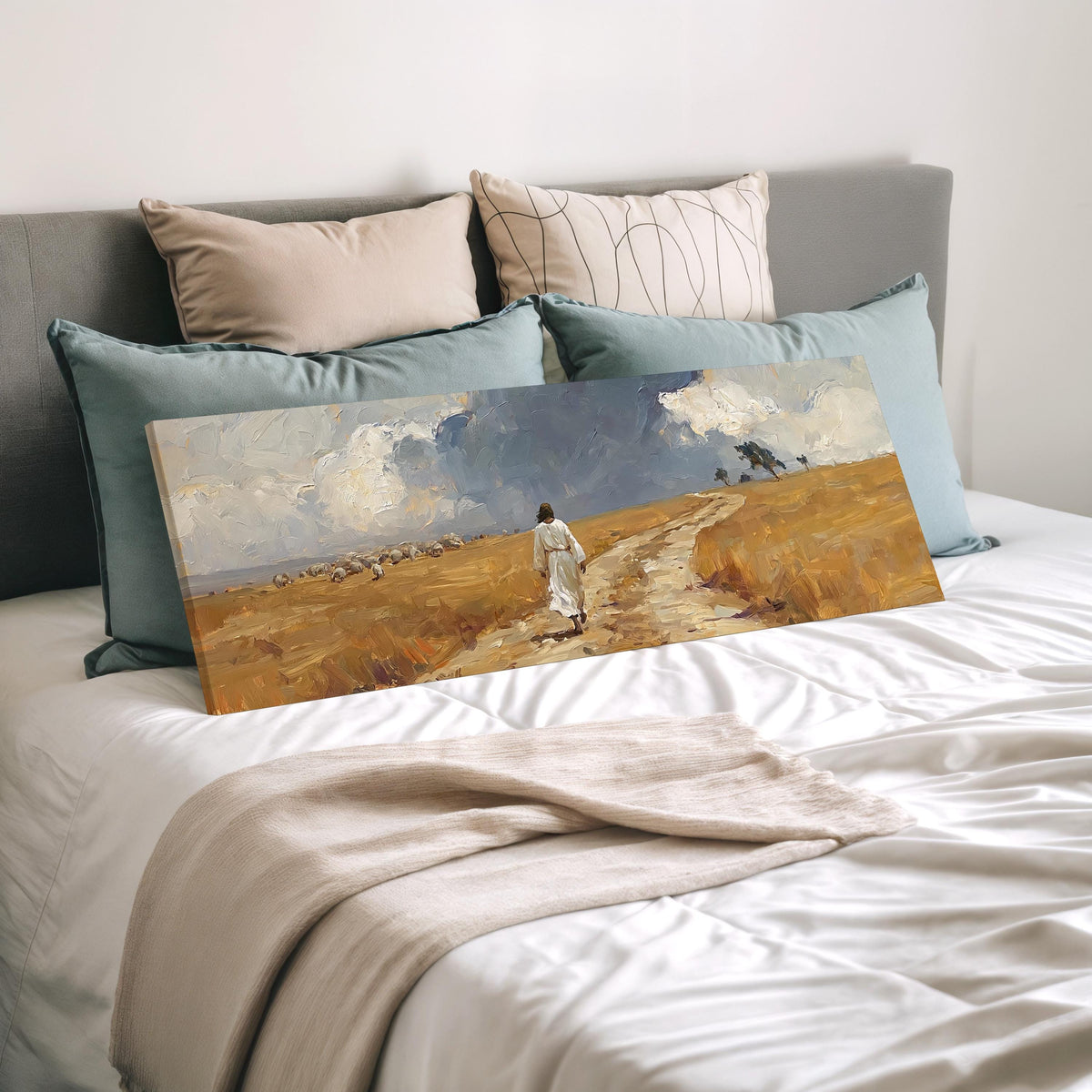 Jesus walking a field path with grazing sheep wide panoramic canvas print laid on a bed to show its size