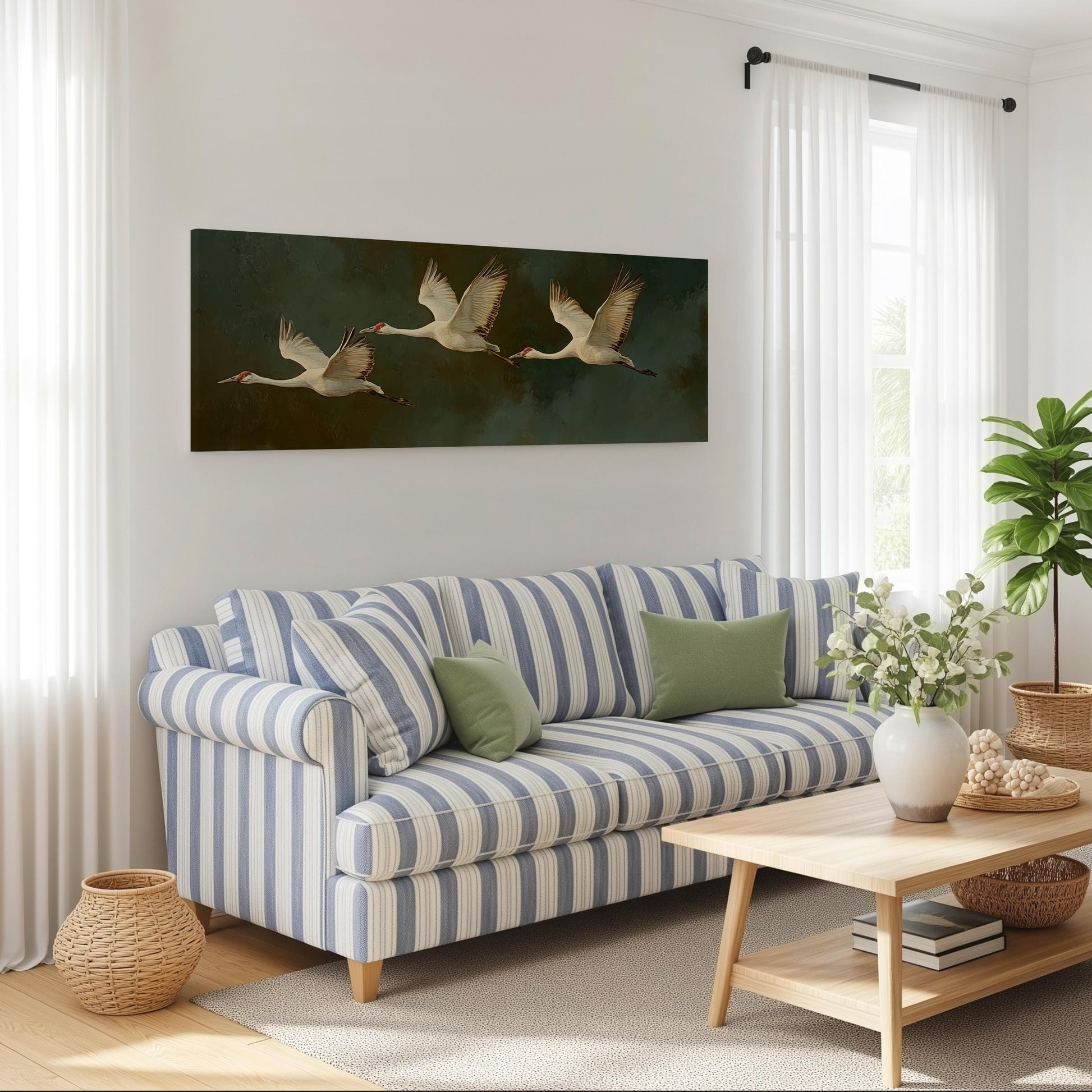a cozy living room with a striped blue and white sofa, a wooden coffee table, and a large painting of three swans flying across a dark background. The room is decorated with a potted plant, a basket, and a vase with flowers, creating a warm and inviting atmosphere.
