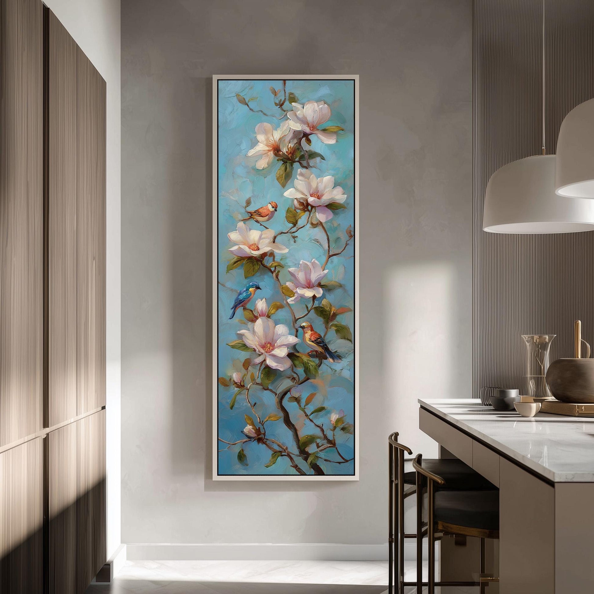 a large painting of a branch with pink and white flowers, along with several birds perched on the branches. The painting is hung on a wall in a room with a kitchen counter and chairs visible in the background.