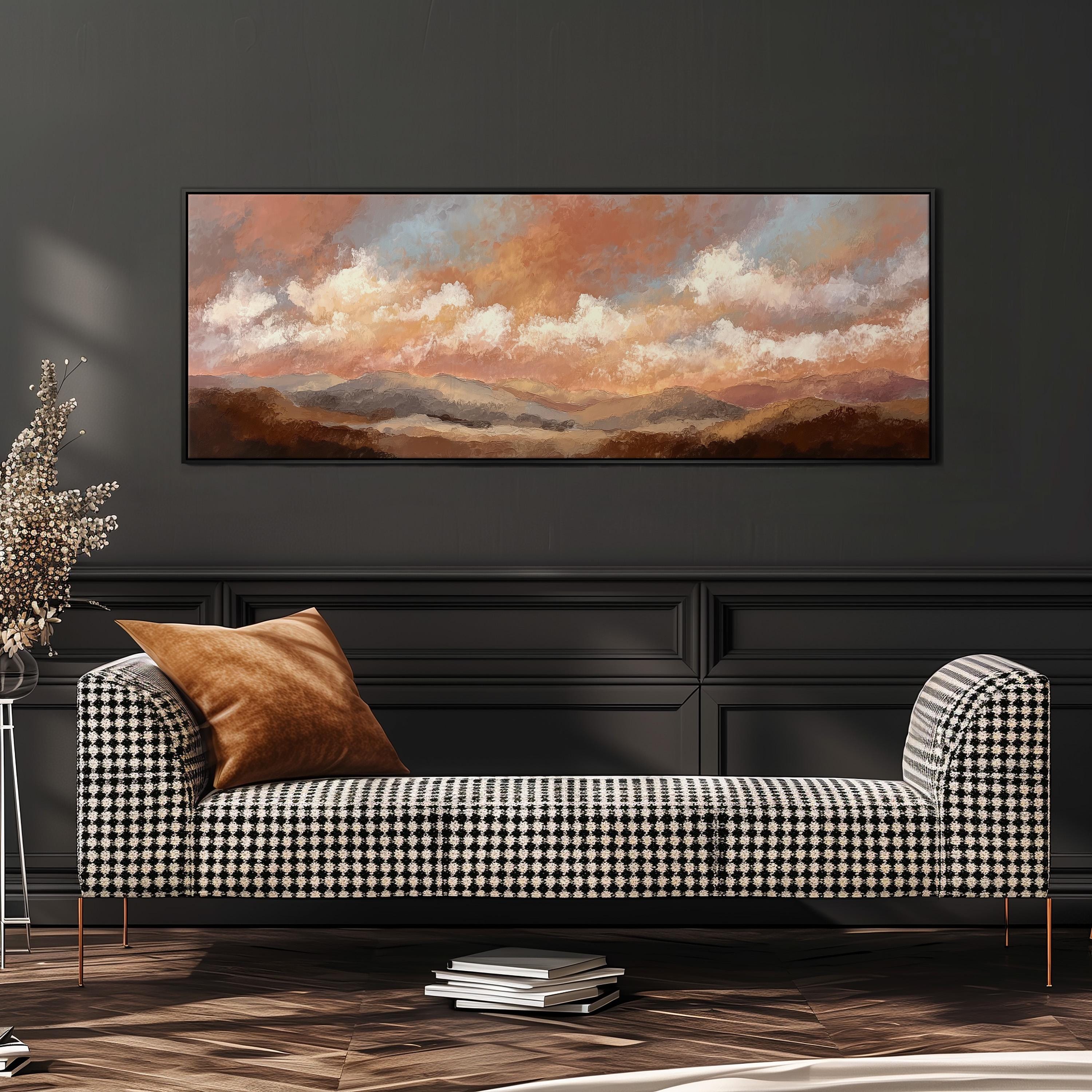 a large, rectangular painting of a landscape with mountains and clouds hanging on a wall above a black and white checkered sofa with a brown throw pillow.