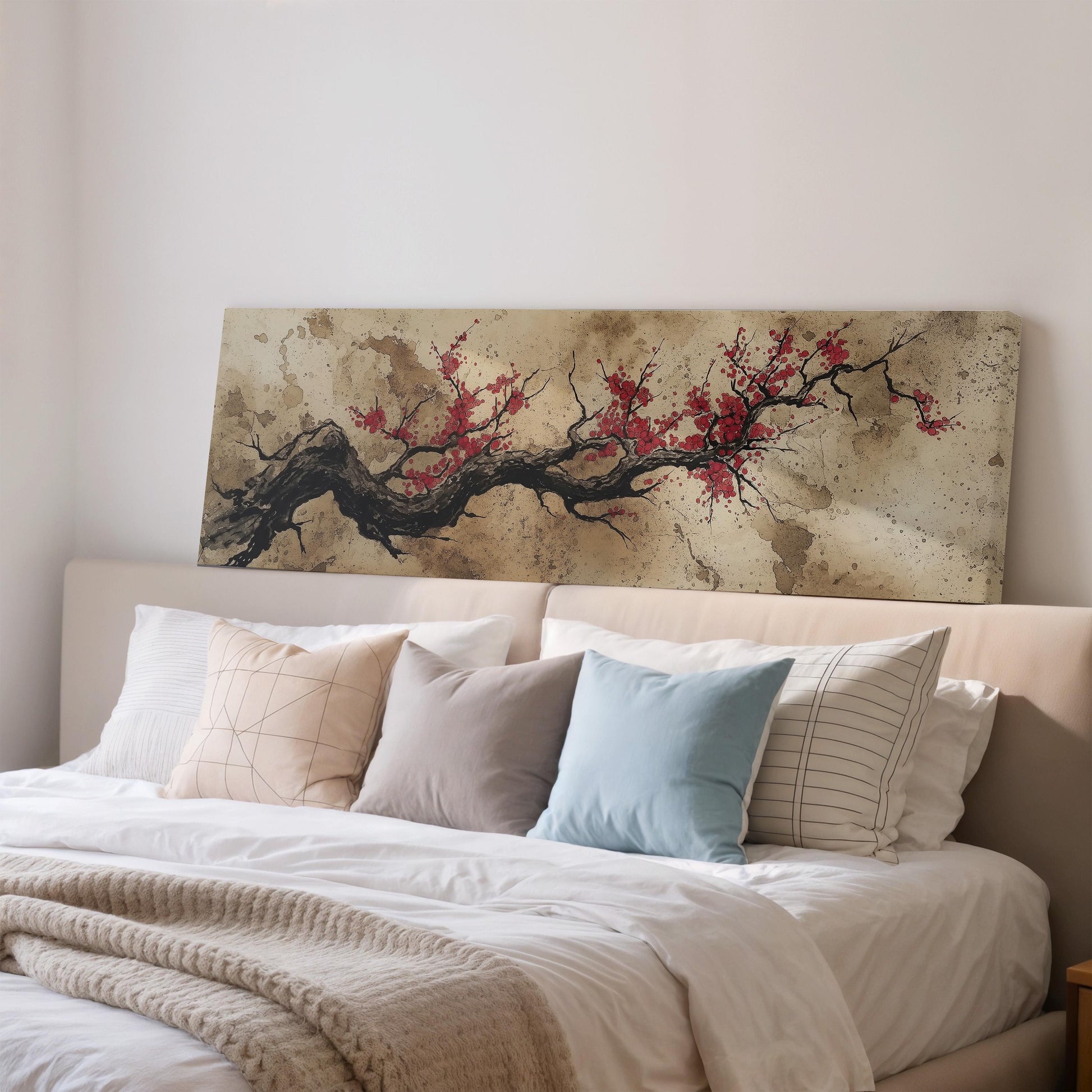 a bedroom with a large bed covered in white sheets and pillows. Above the bed, there is a painting of a tree with red flowers.