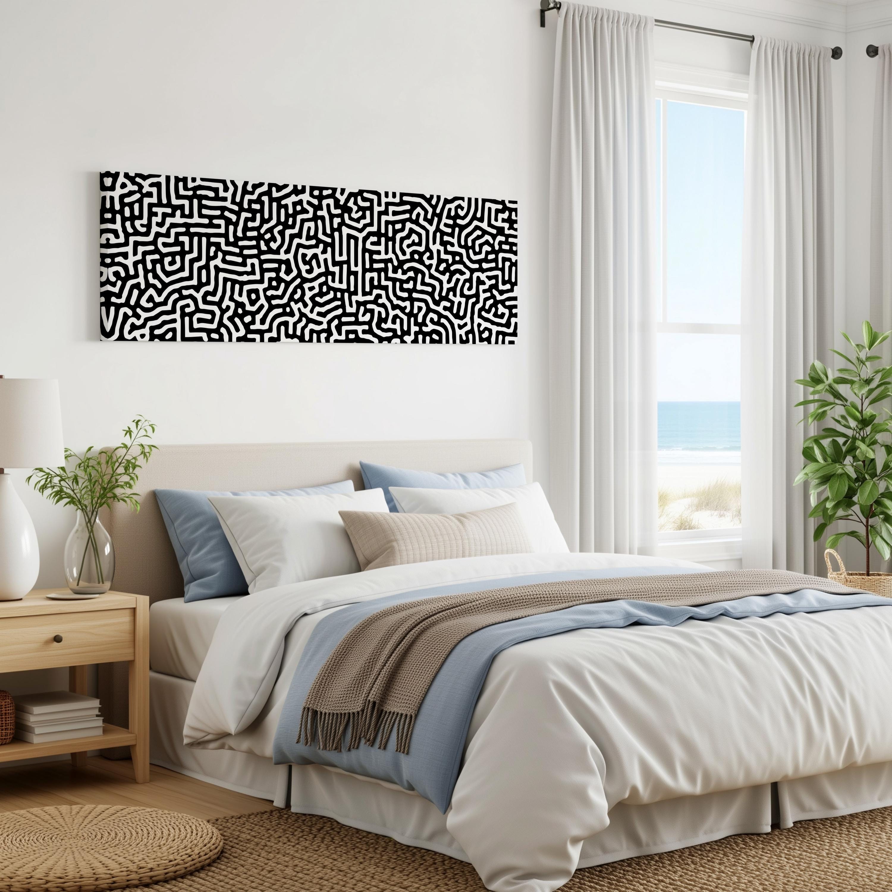 a modern bedroom with a large bed, a nightstand, and a large window overlooking the ocean. The room has a minimalist and clean design, with a black and white abstract artwork hanging on the wall above the bed.