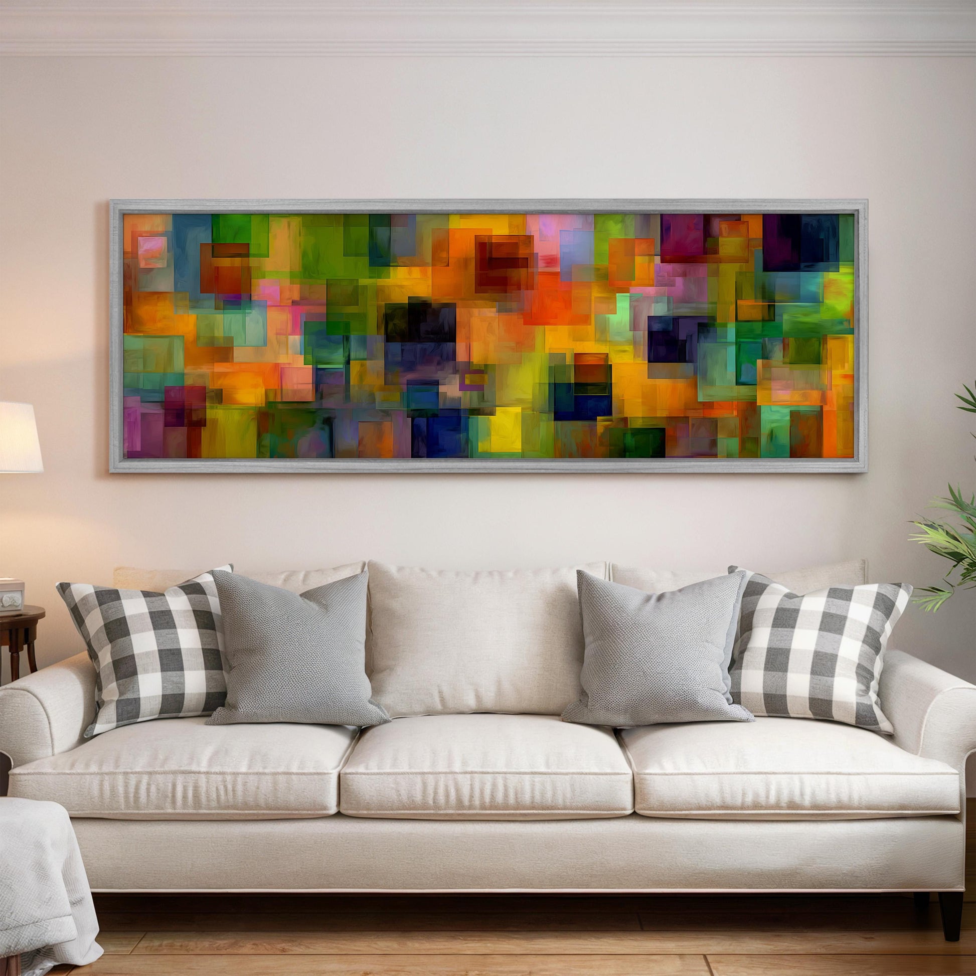 a large, colorful abstract painting hanging on a wall above a white couch with gray and white patterned pillows.